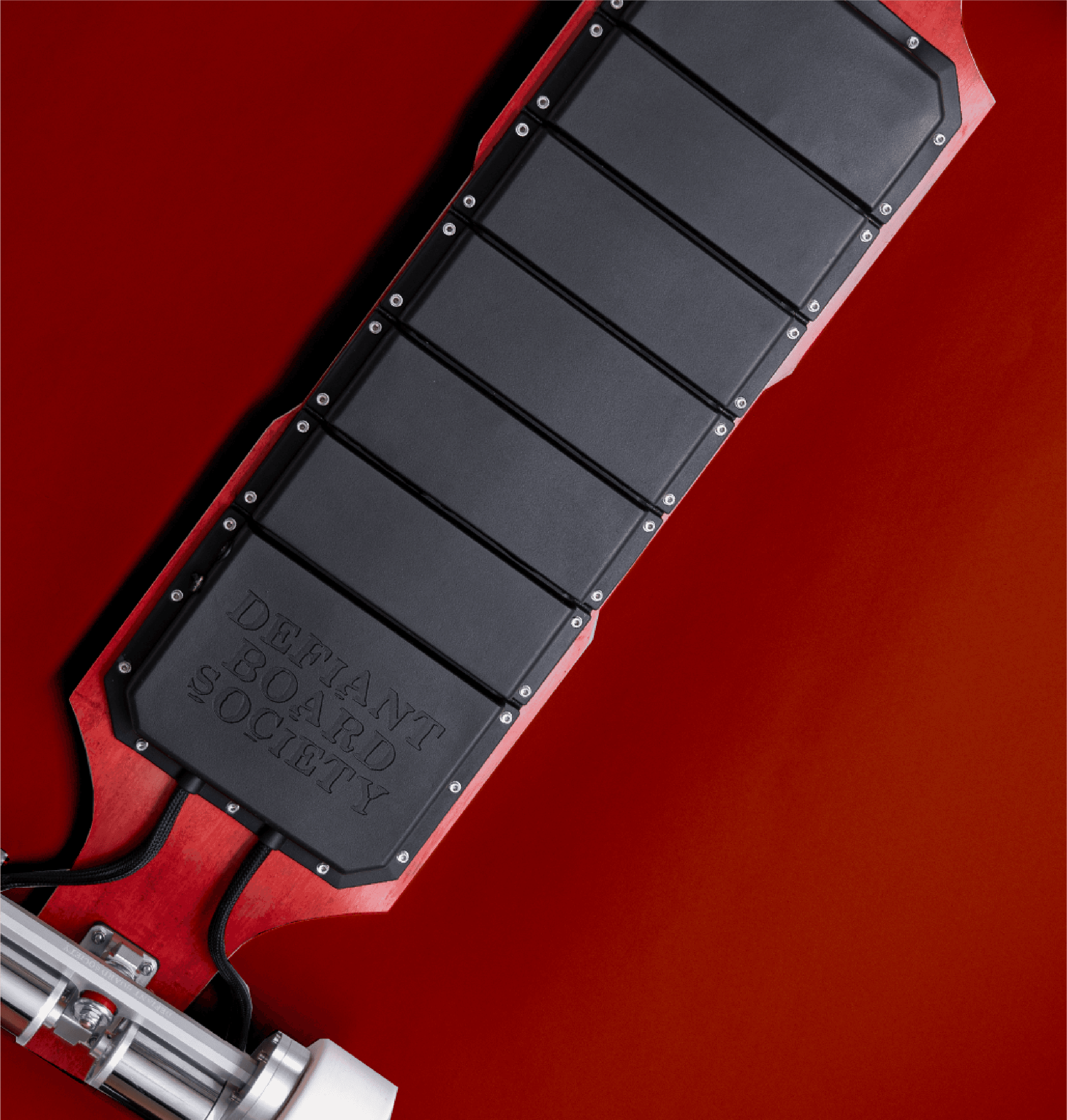 Close-up of electric skateboard underside with battery enclosure on red background