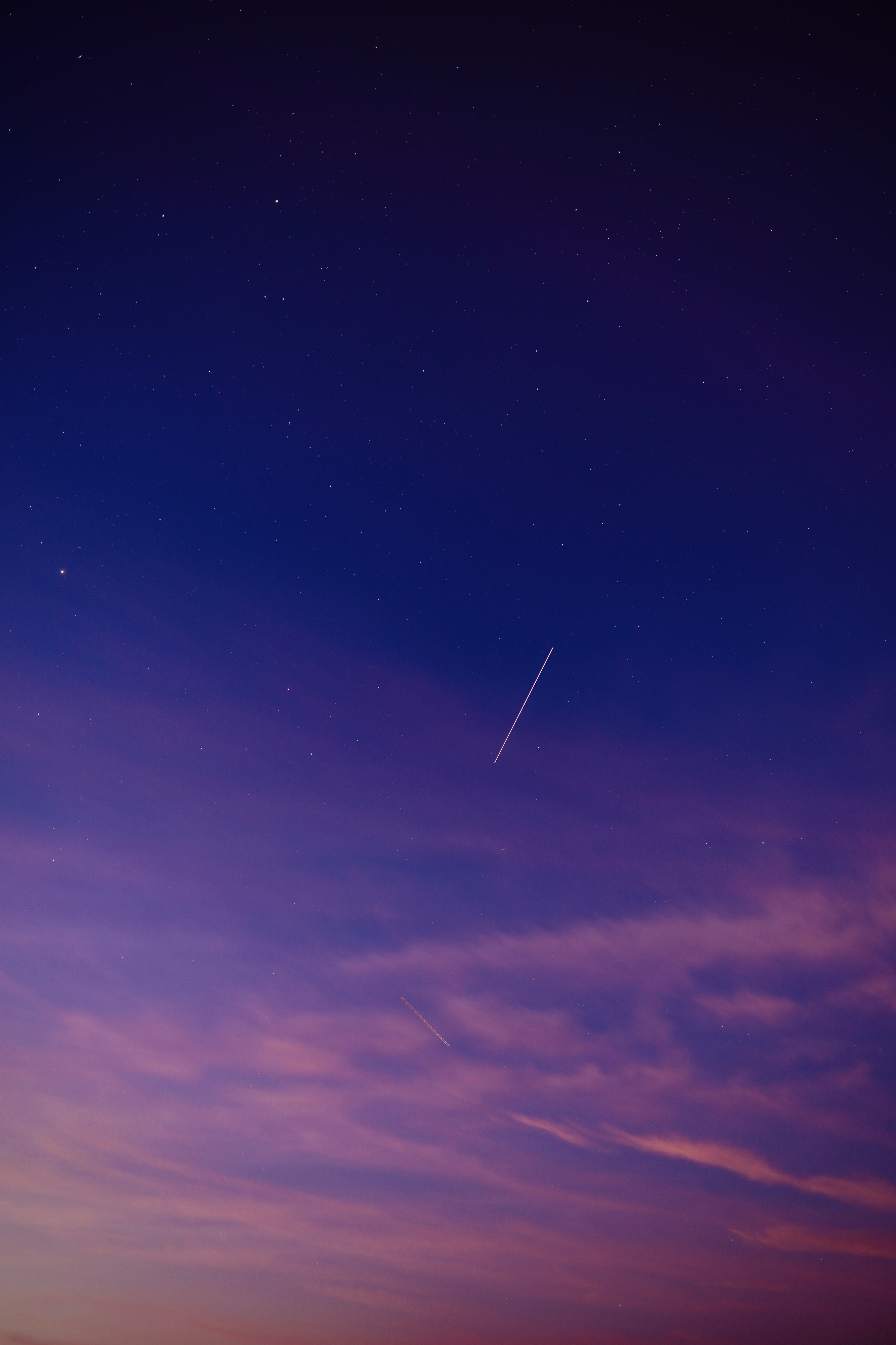 A gradient sky transitioning from deep blue to soft purple with wispy clouds scattered throughout.