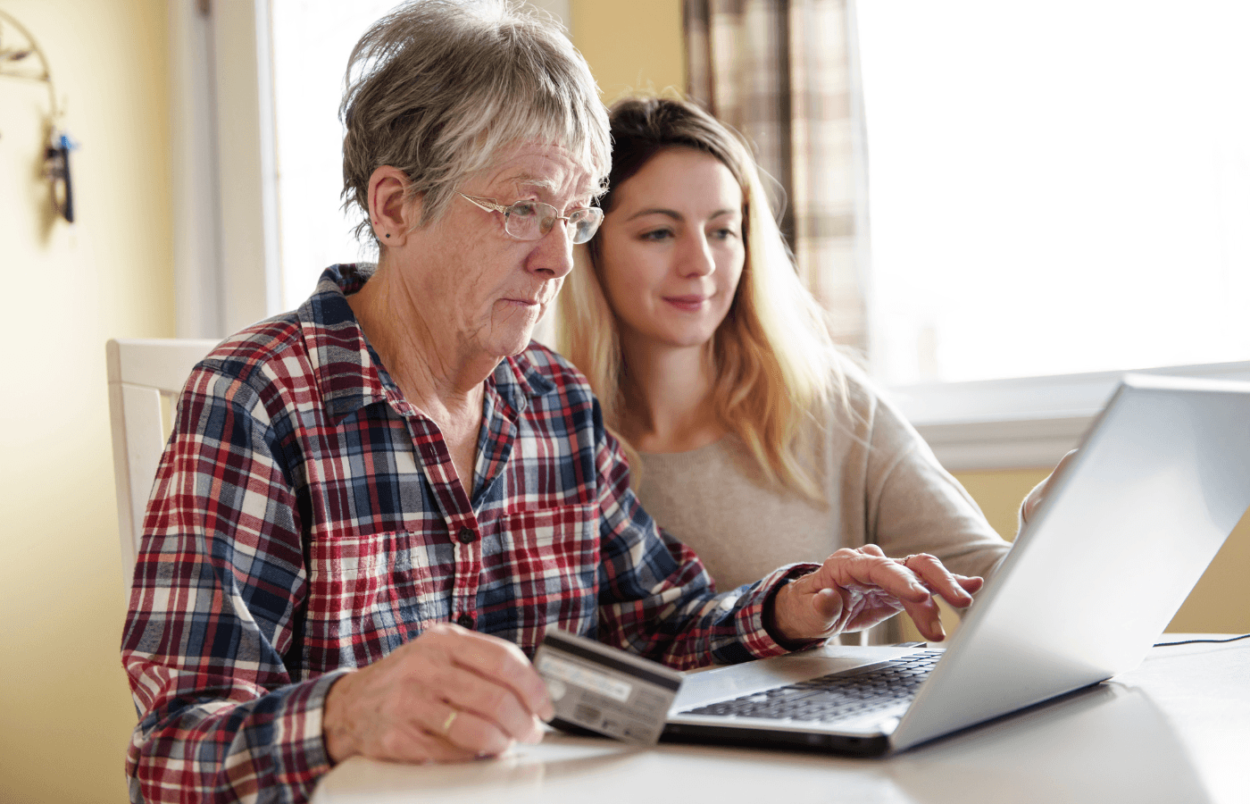 young woman and older woman looking over finances on computer