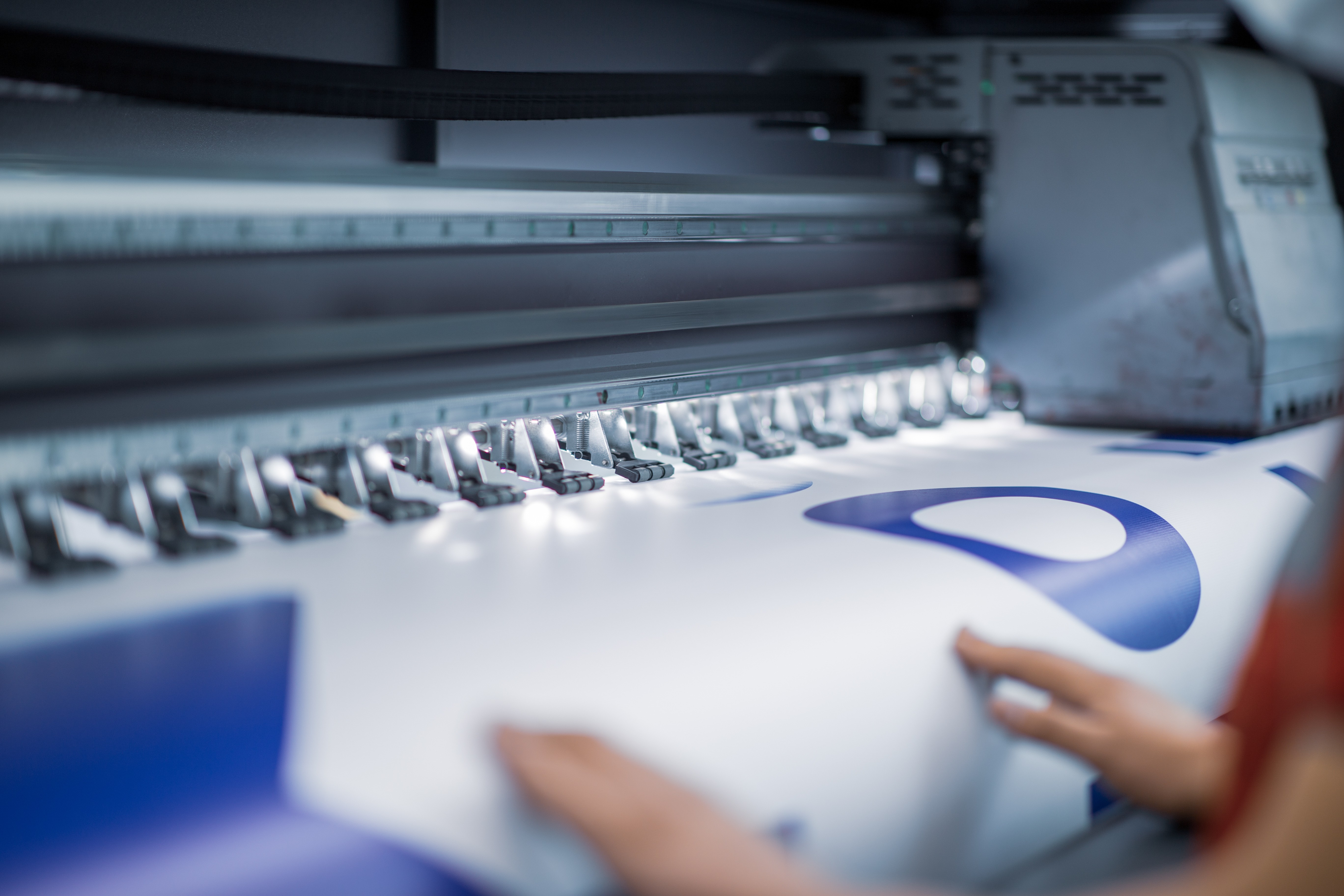 Black and white image of people working at a table with laptops, showing hands gesturing during discussion of digital content displayed on screens, with fabrica® logo in the corner.