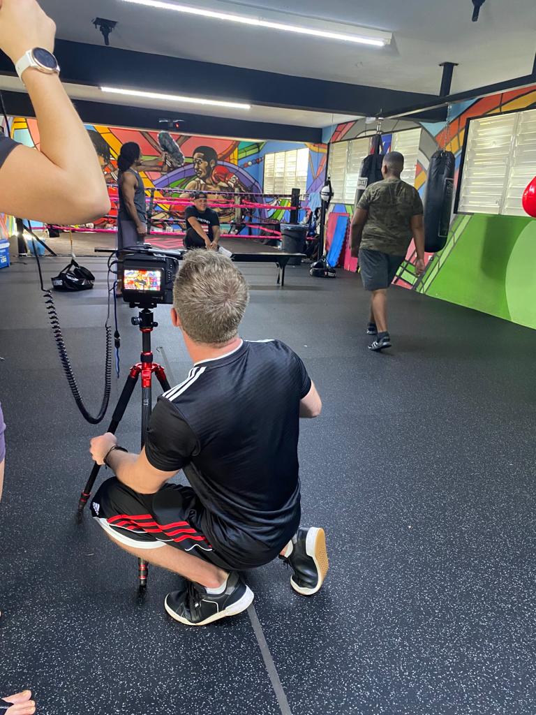 Cameraman filming a boxing scene inside a Puerto Rico gym for documentary production