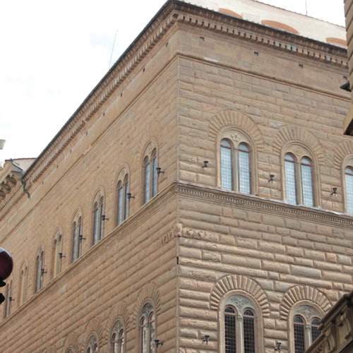 Two people standing and observing a large religious painting displayed in an art gallery.