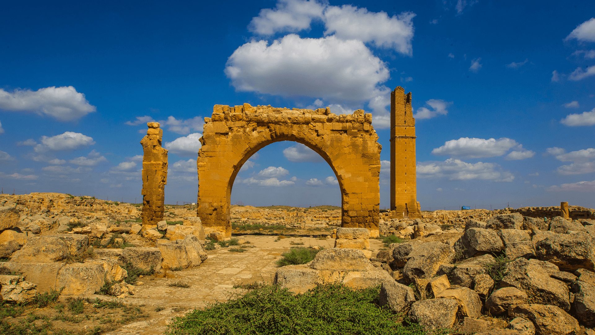 Ancient ruins and historic stone arch in Harran, southeastern Türkiye, archaeological landscape with desert scenery and dramatic blue sky
