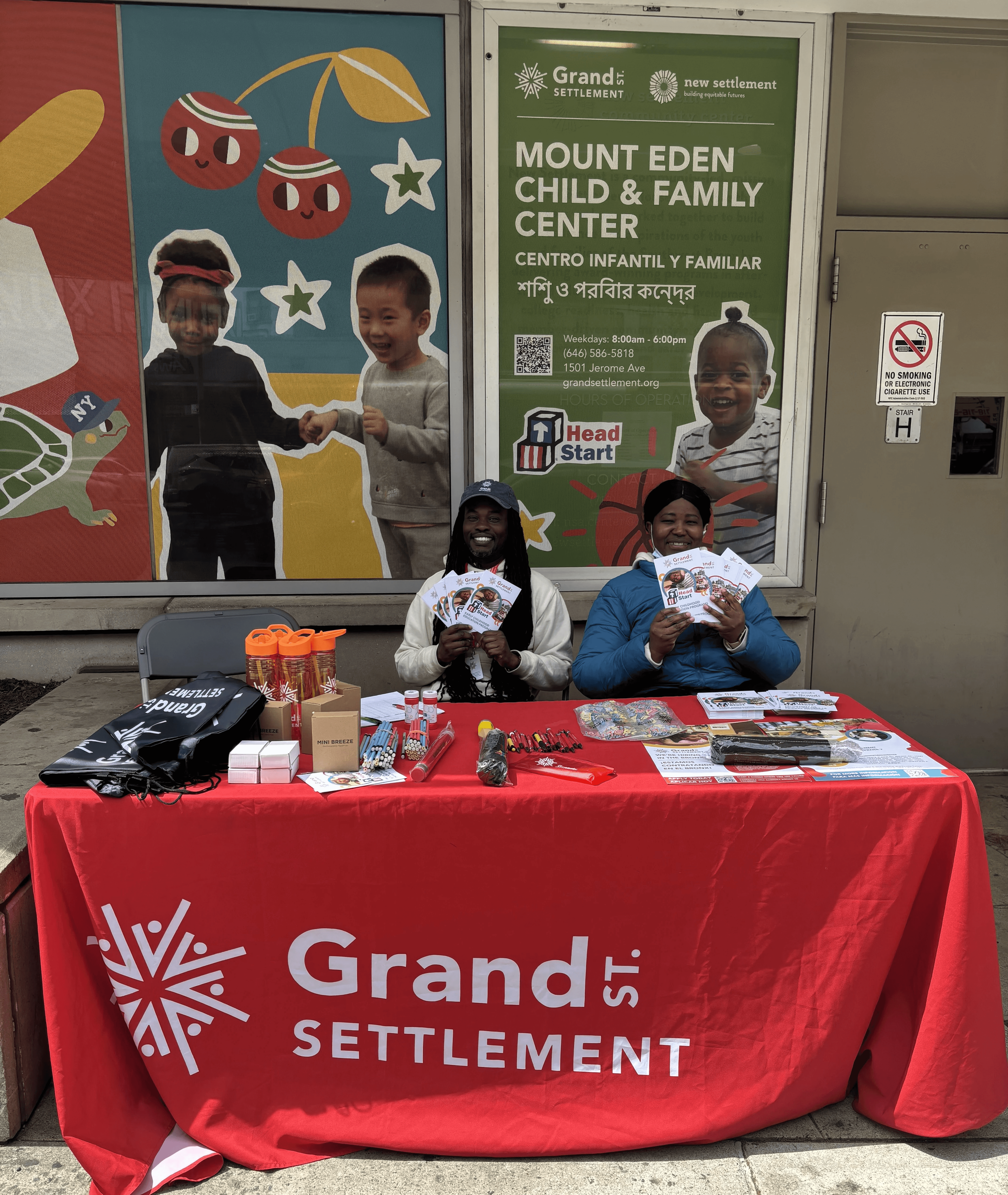 Twos taff members table in front of their colorful child and family center.
