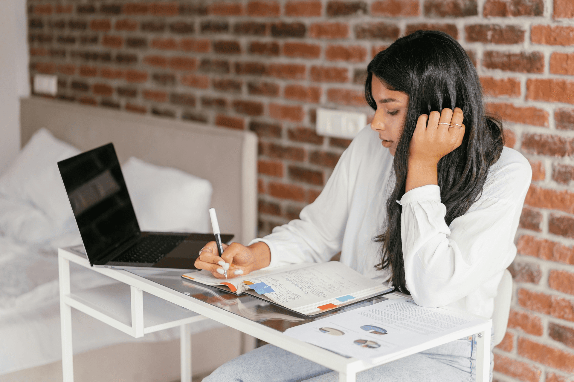 Student writing a research paper with Chicago style citation guide open on desk