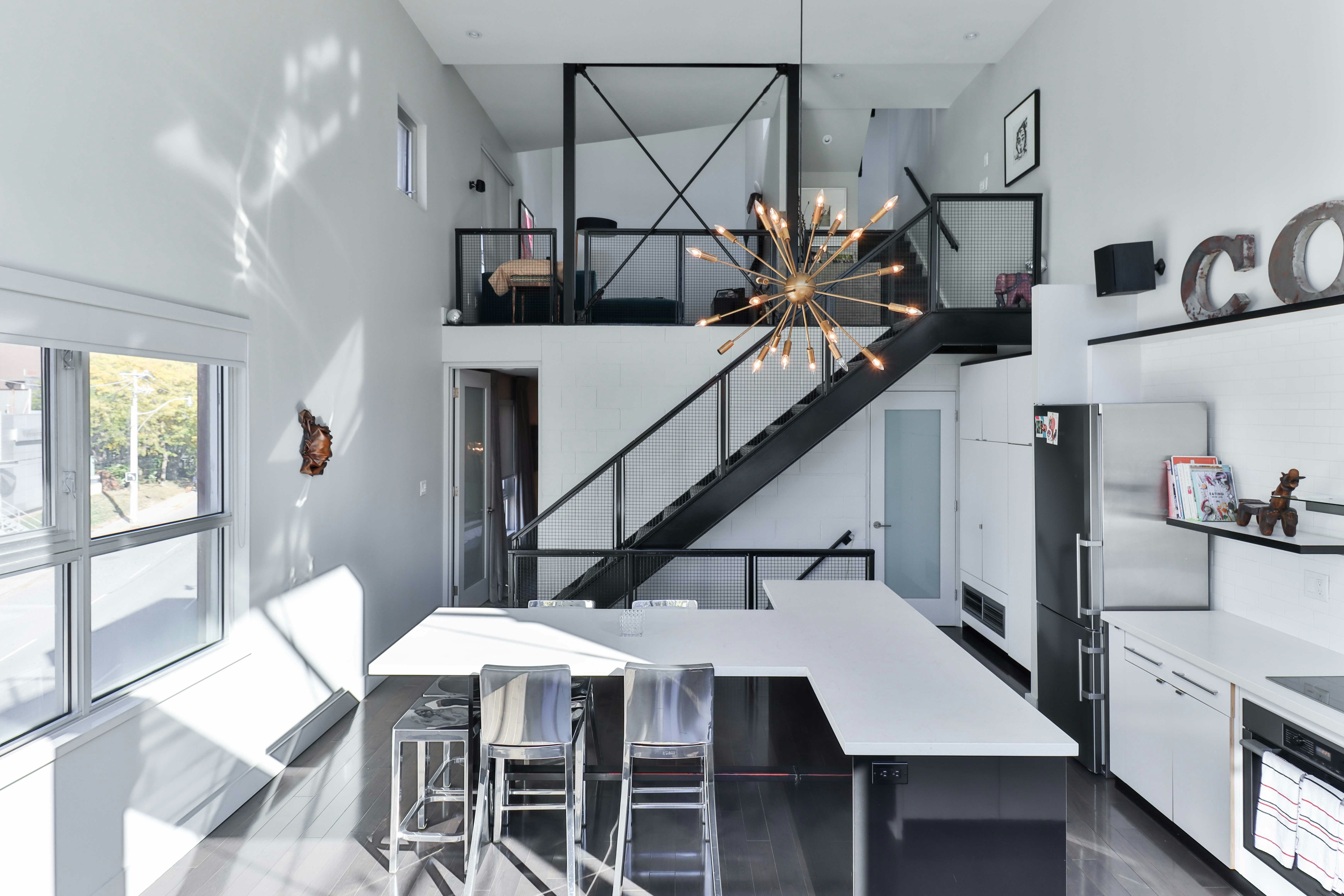 Loft bedroom with exposed brick walls and a modern staircase.