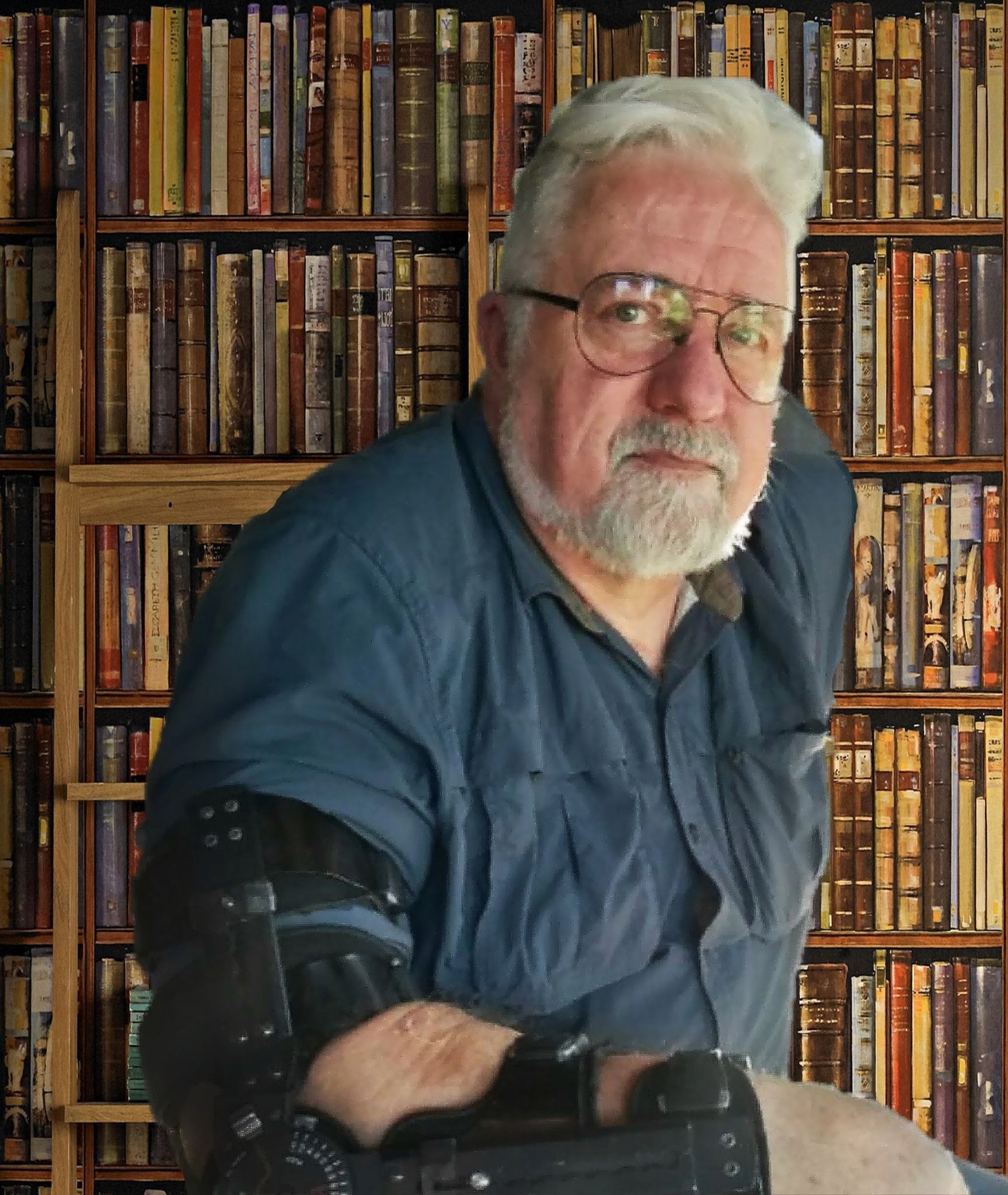 Author Baer Charlton seated in front of bookshelves wearing an arm brace.