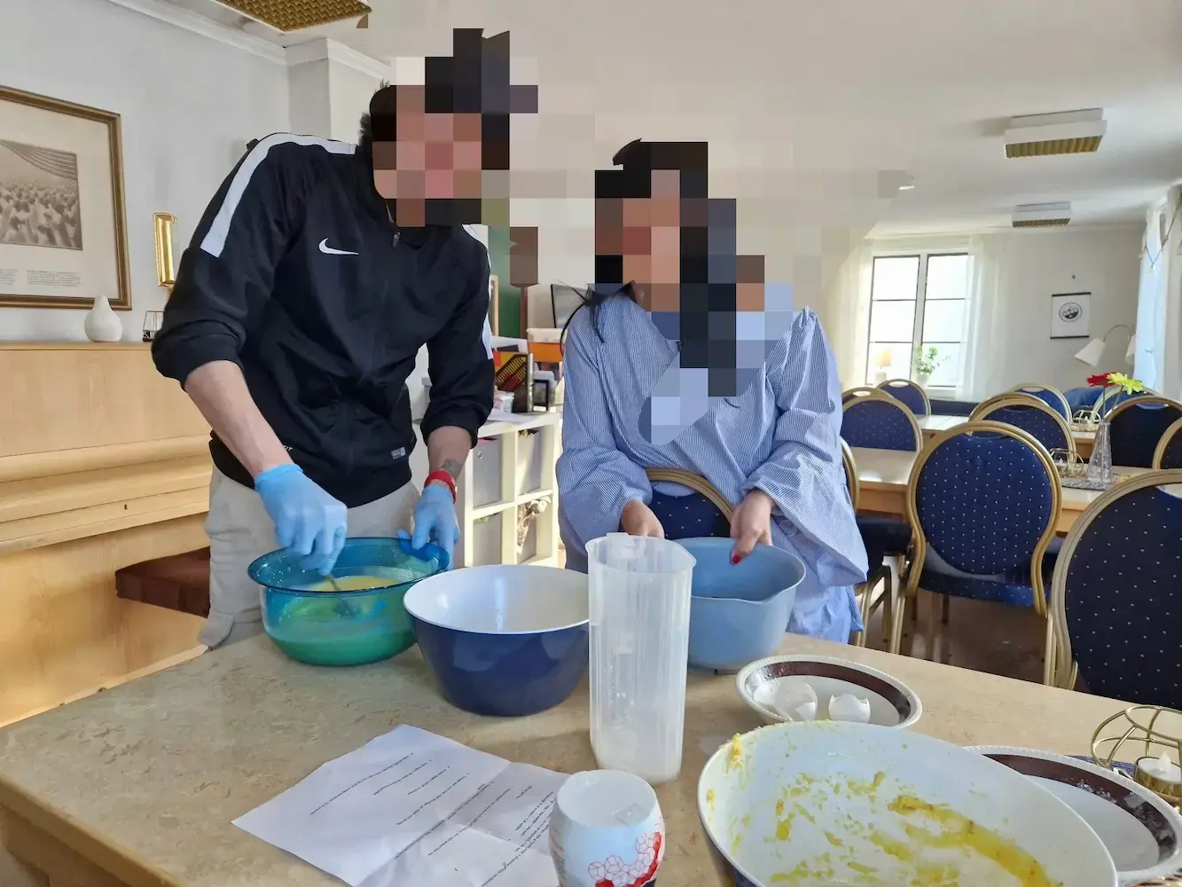 Två personer förbereder mat tillsammans vid ett bord i Vinternatts lokaler.