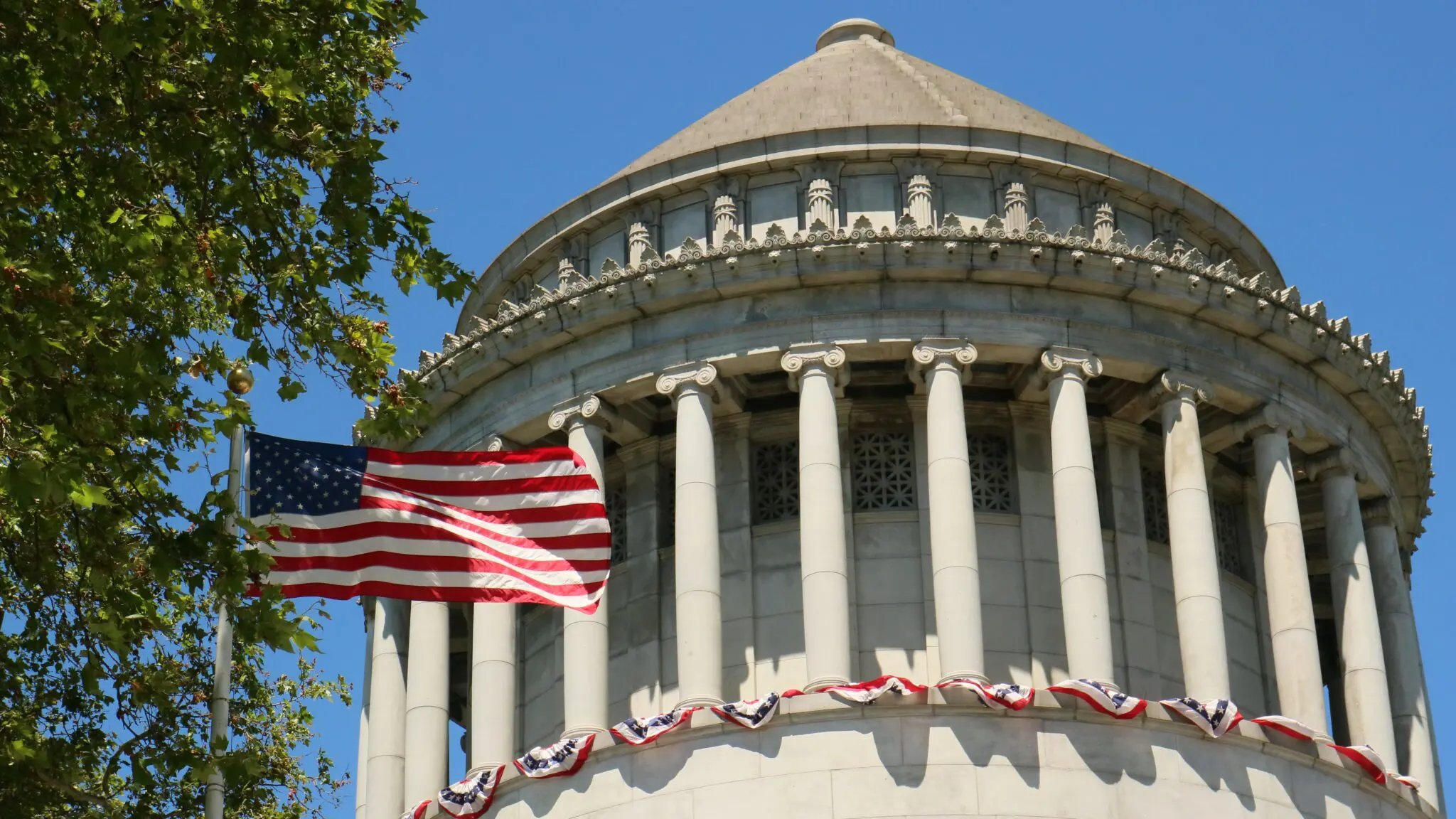 US State building with an American flag waving high infront of it
