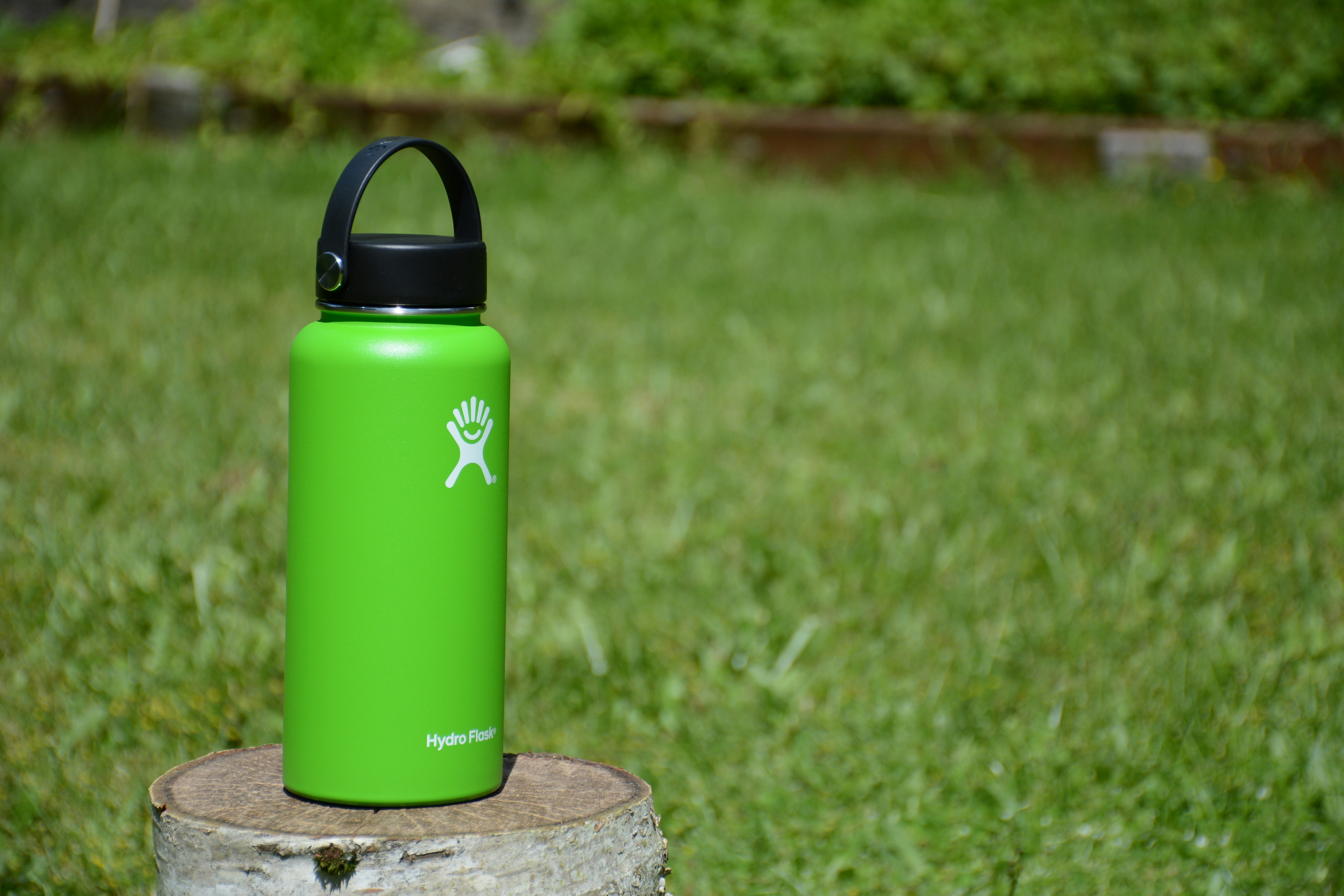 green Hydro Flask tumbler on wood slab