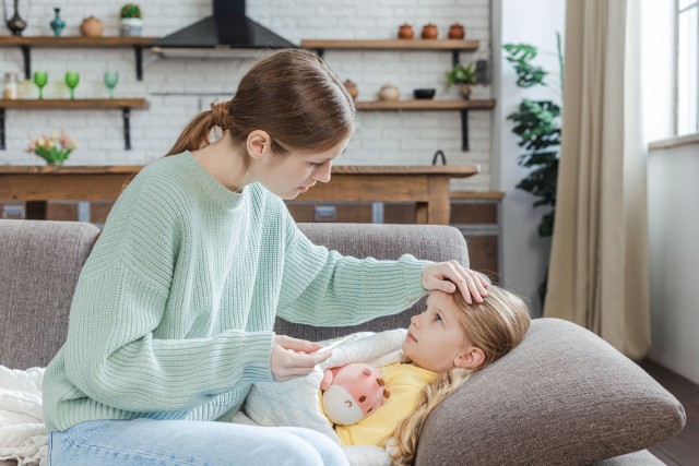 額に手を当てられている子供