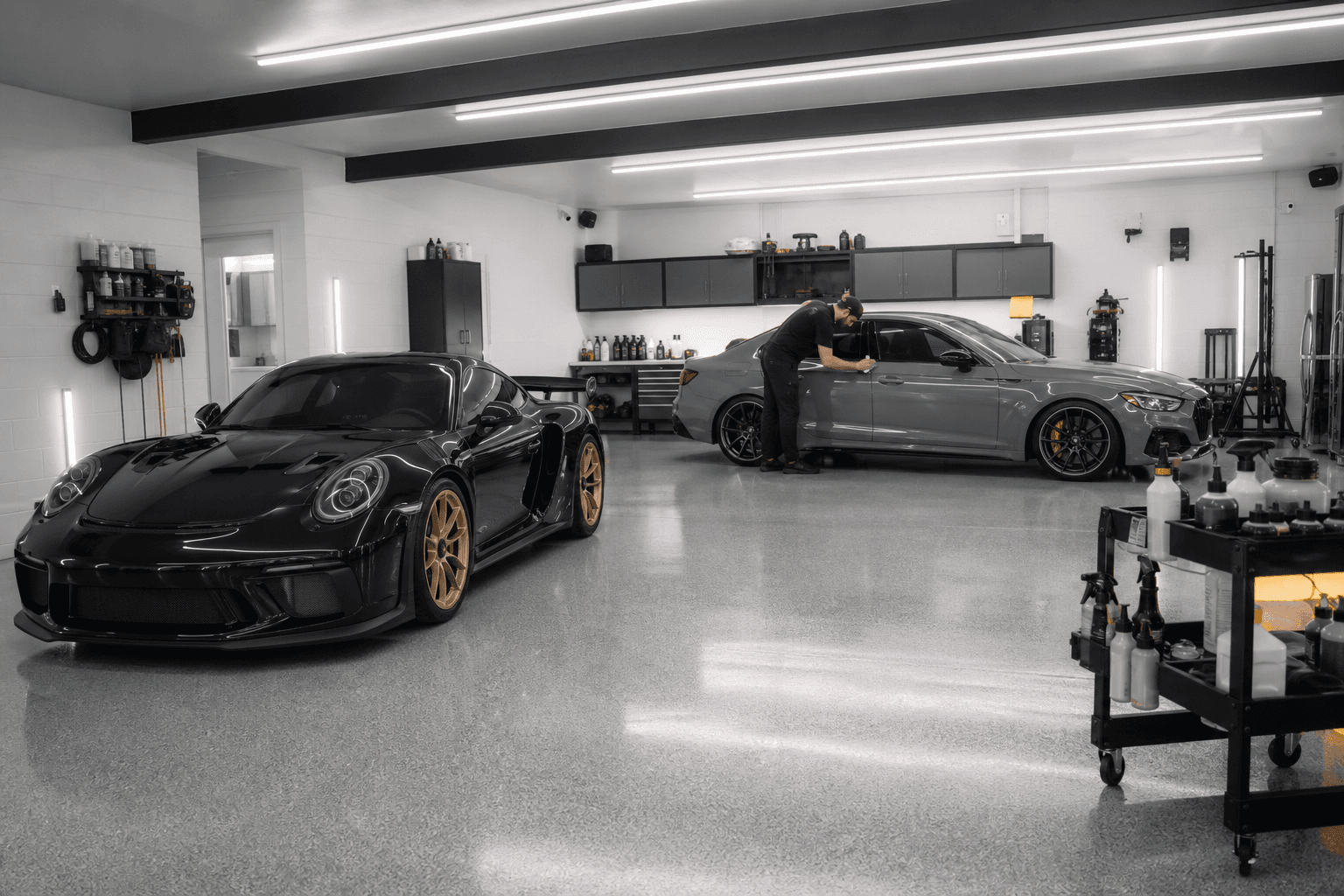 Clean professional tint and detail studio with two cars being worked on