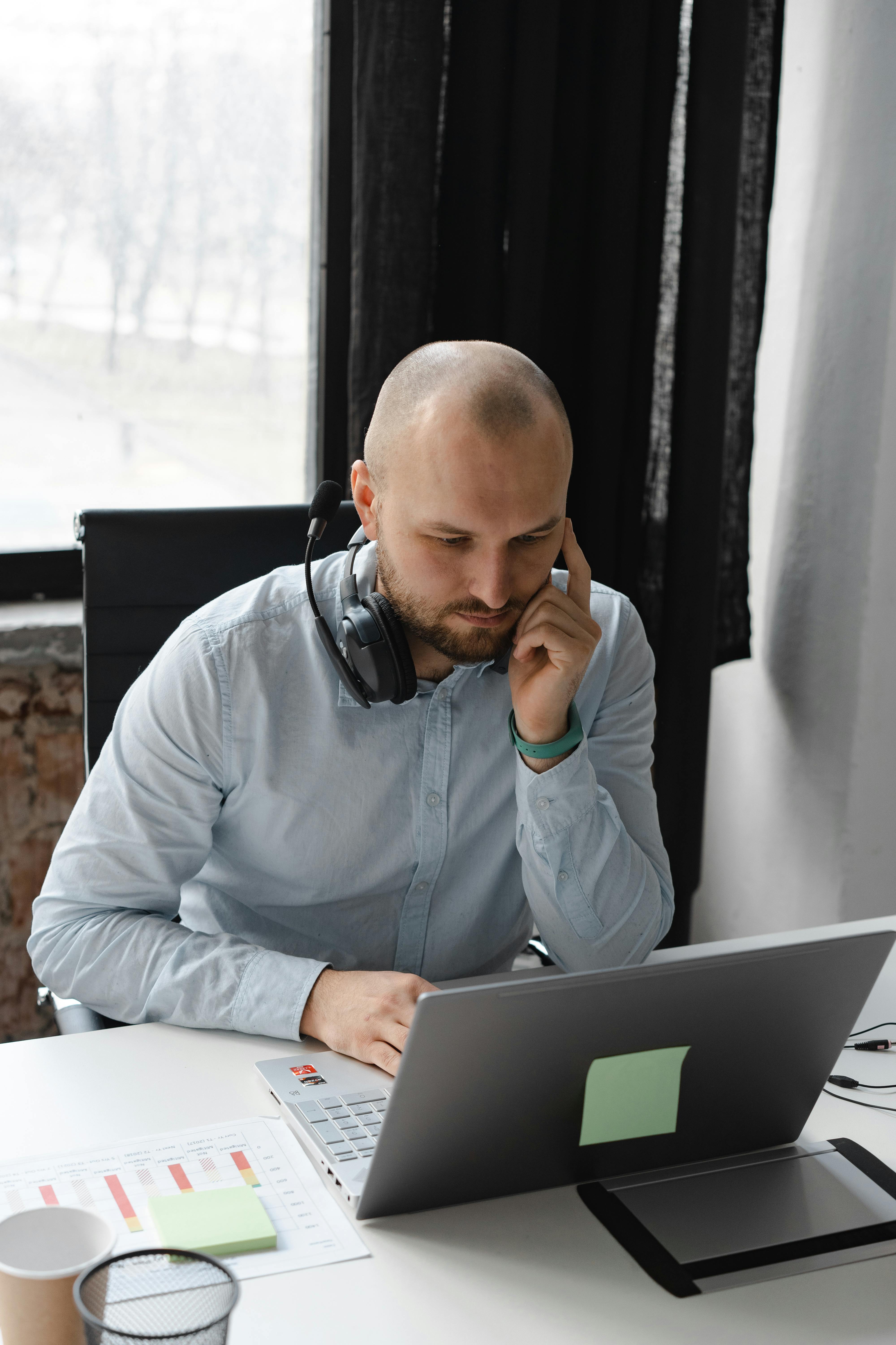 man smiling while sitting and using MacBook