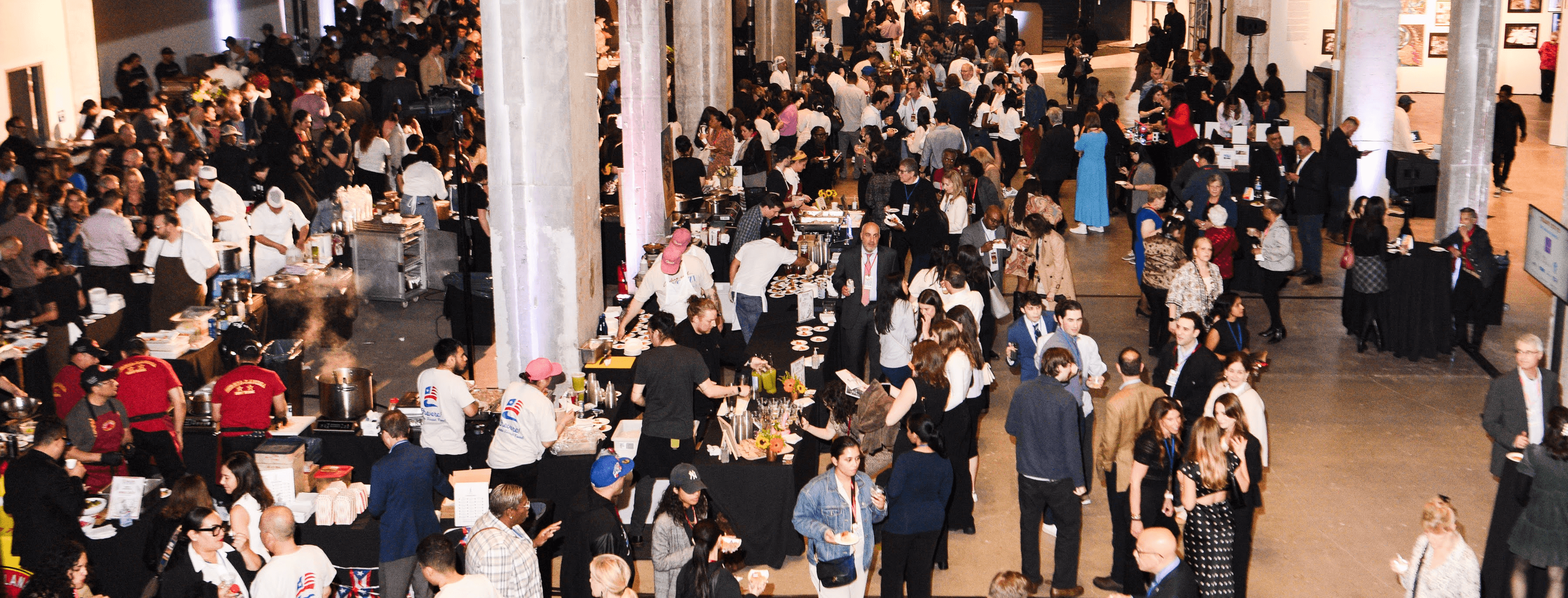 A busy event space filled with people eating food from different vendors