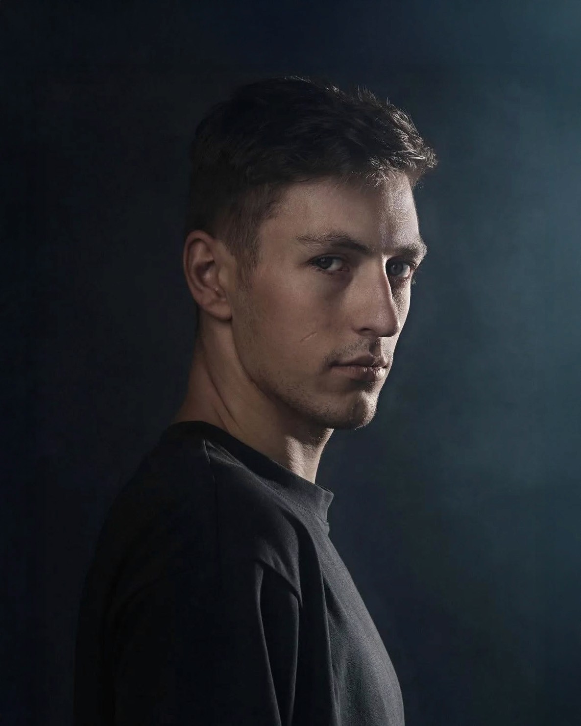 headshot of male in dark background