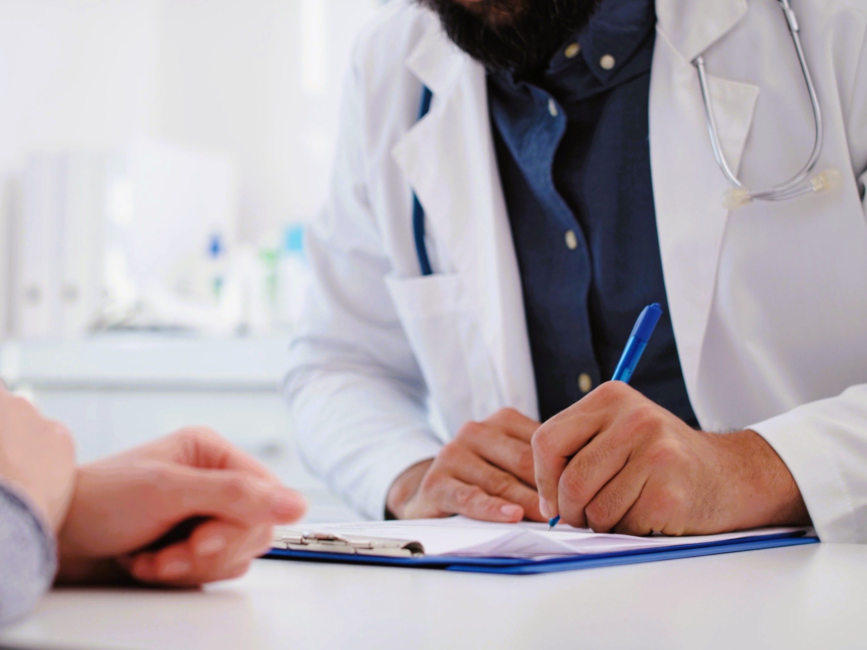 doctor writing a prescription for tablets for weight loss to give to a patient who is a candidate for them