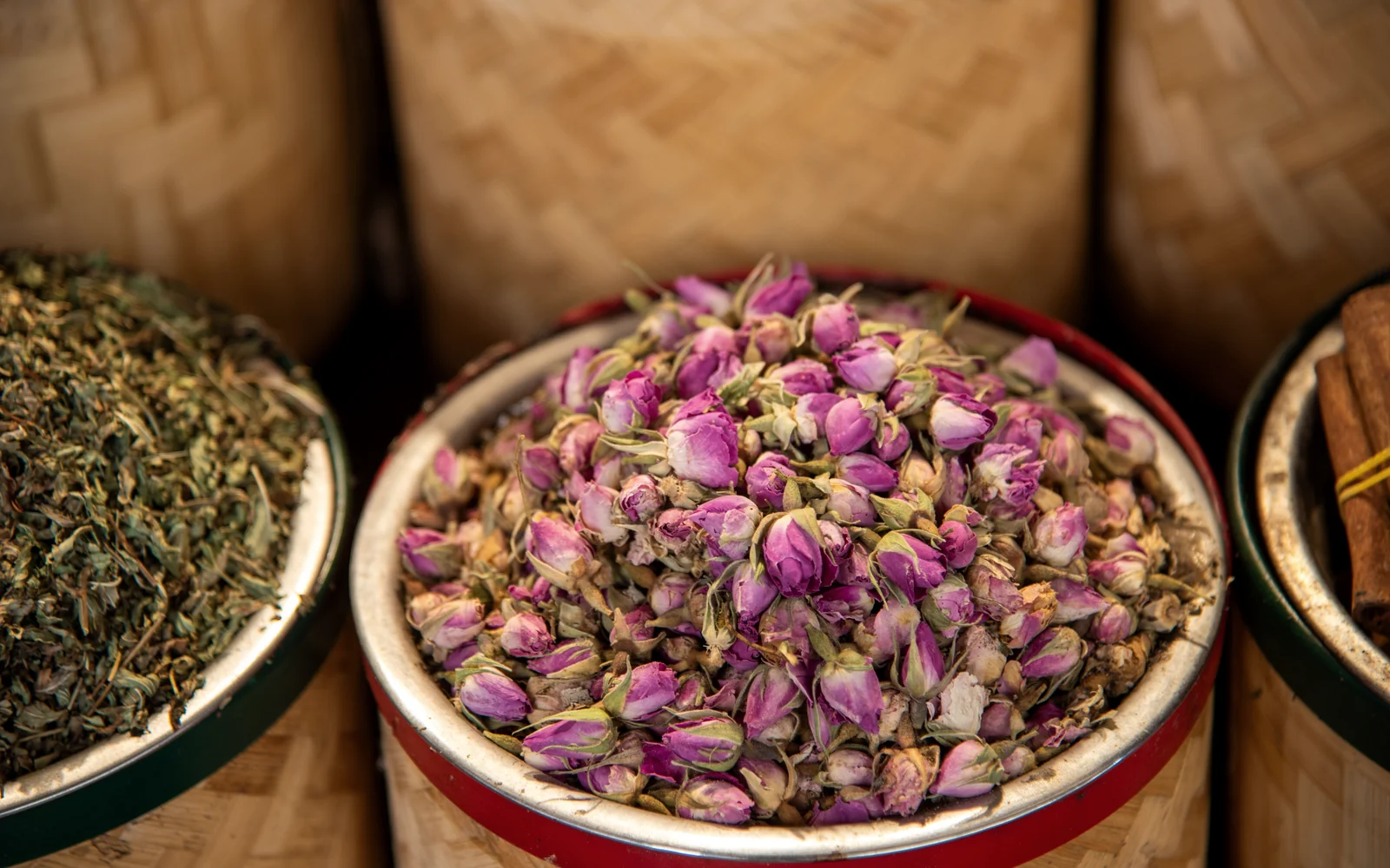 Dried rosebuds displayed among aromatic materials at a traditional market.