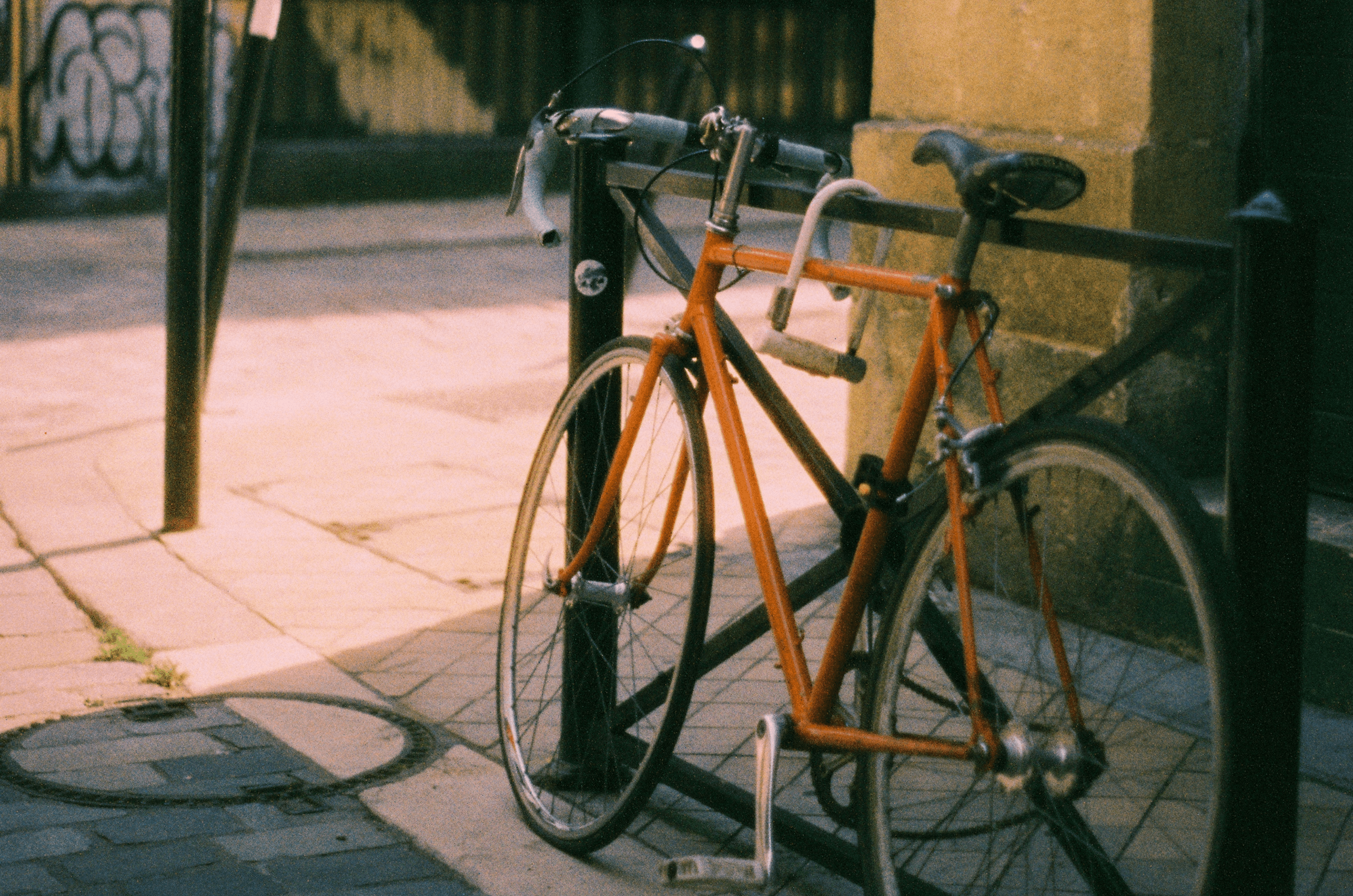 Vintage orange bicycle locked on a city street, representing how B2B marketers can move faster and stay secure by choosing the top programmatic advertising platforms in 2026