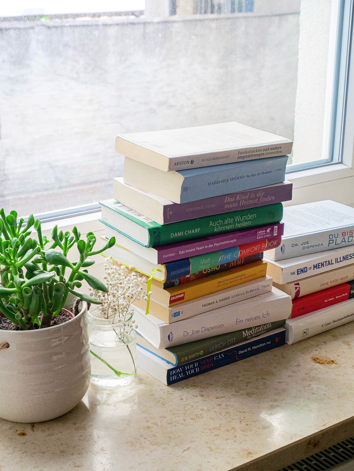 Bücherstapel auf der Fensterbank bei Sonnenschein