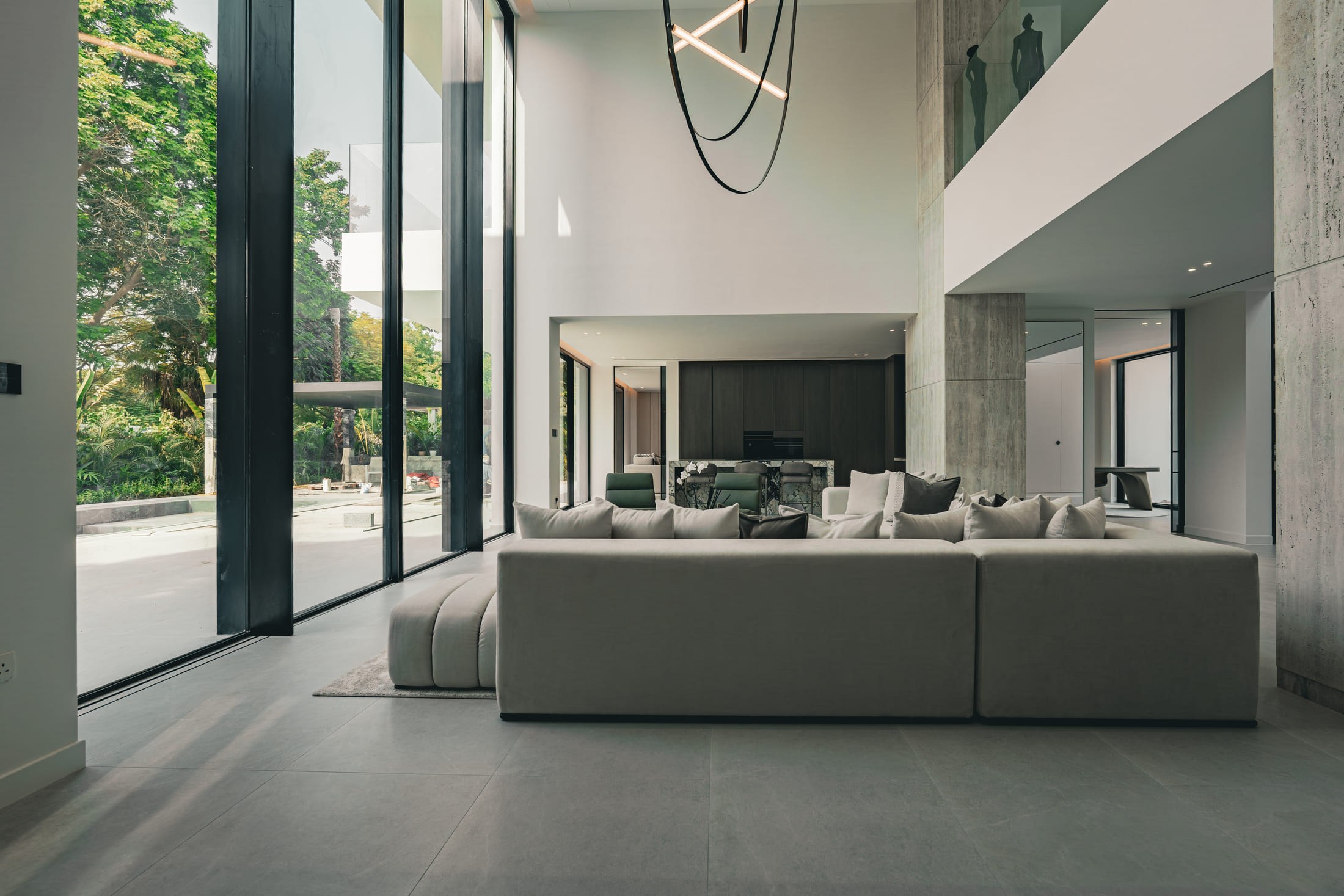 Image of a large villa with big glass windows & a pool 