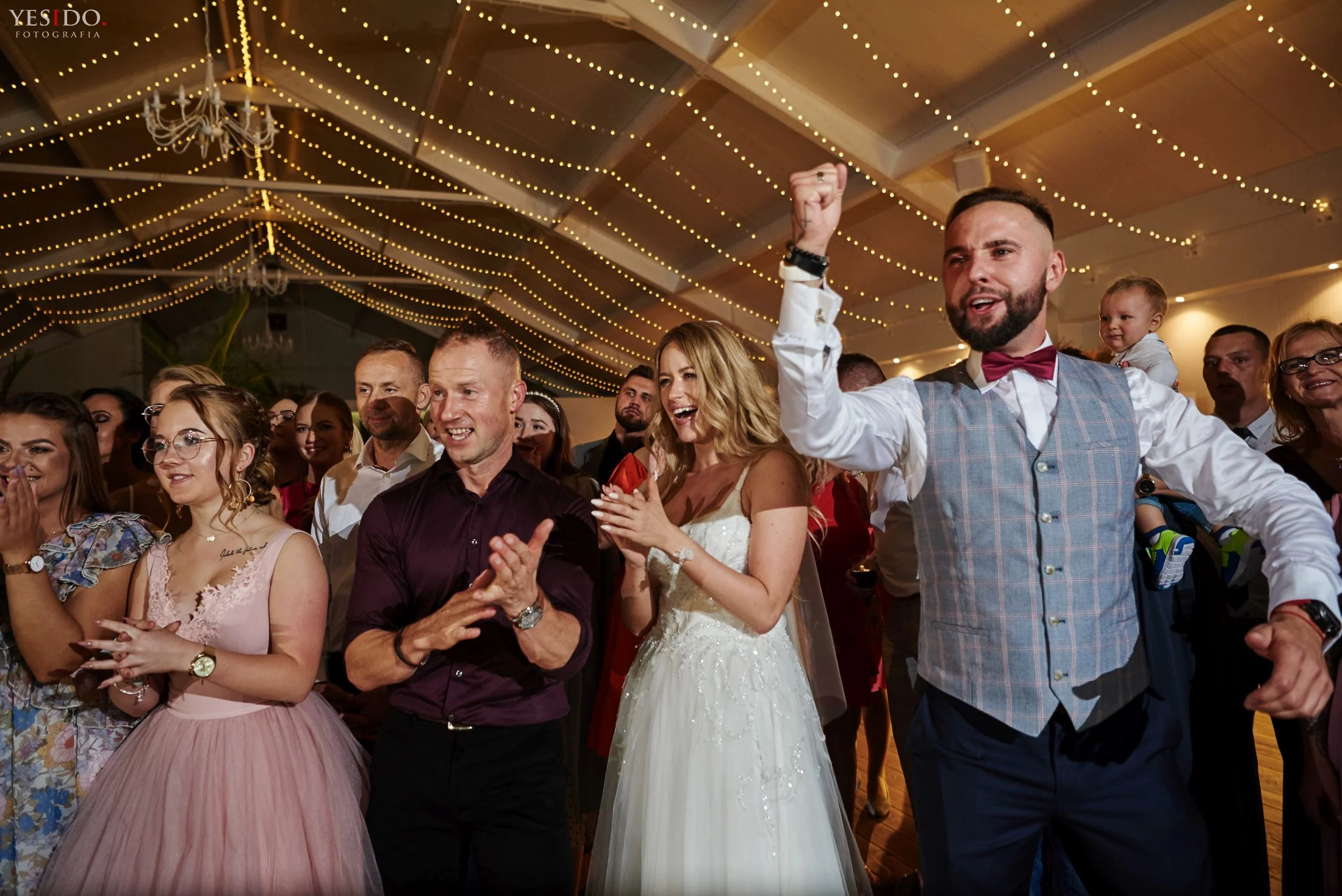 Barman na weselu pokazuje sztuczki barmańskie przed zachwyconą młodą parą.