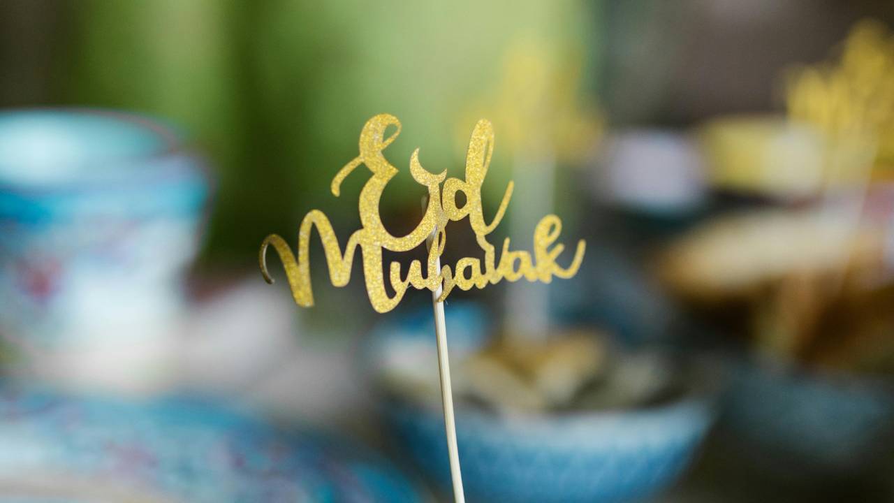 Eid mubarak on a gold card cut out on a stick