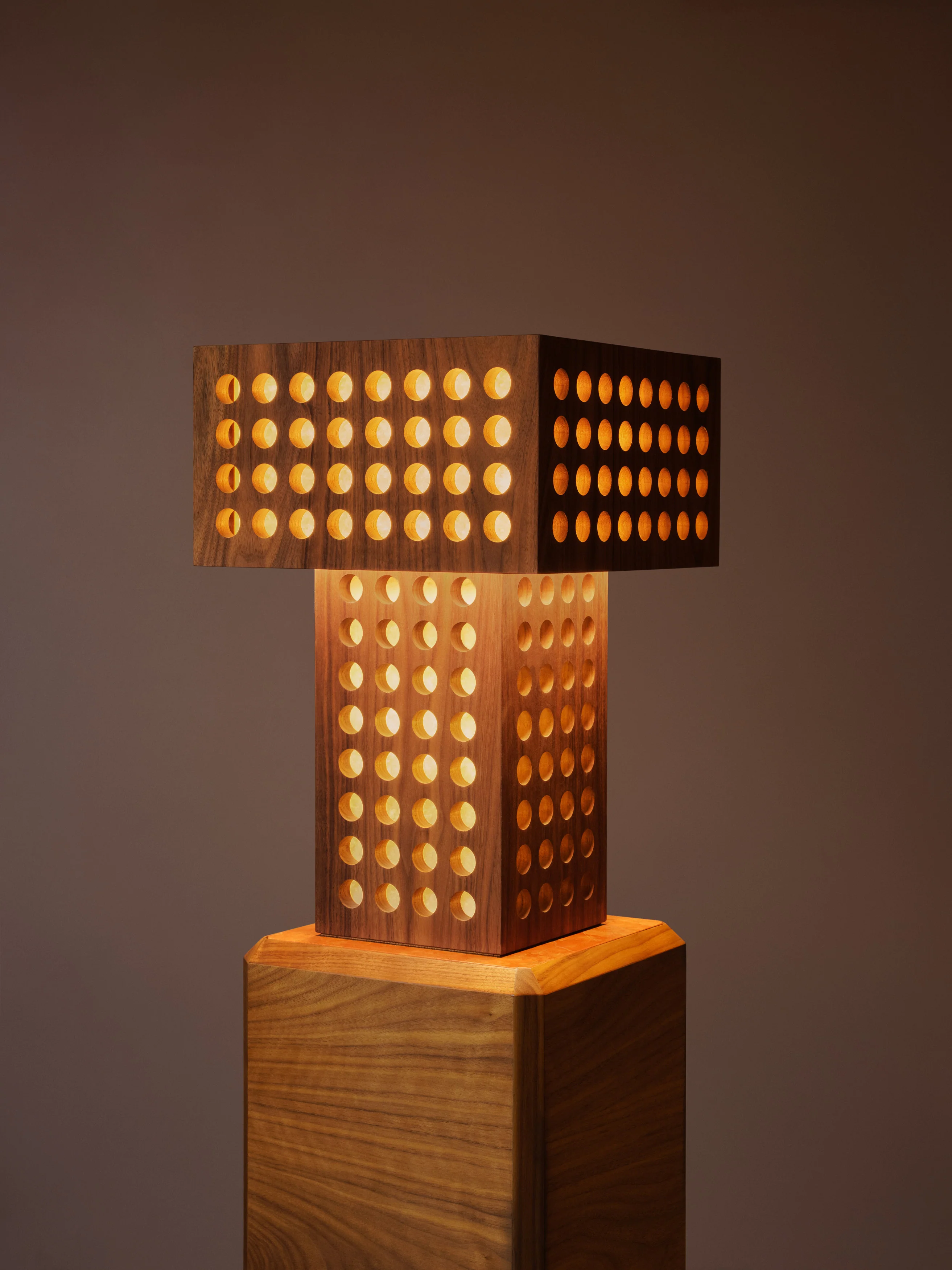 Walnut lamp perforated with half-inch holes throughout