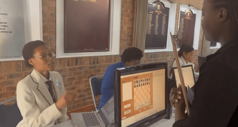 Chisomo demonstrating her chess opener software to other students 