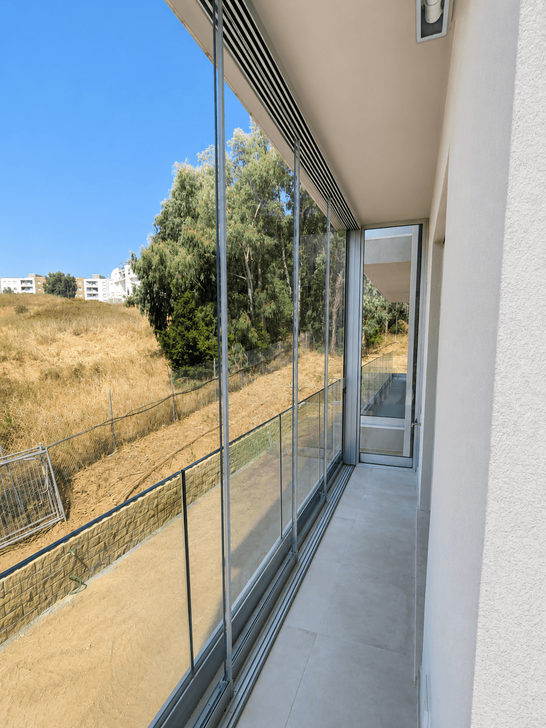 Balcone chiuso con vetrata panoramica trasparente, luminoso e protetto dagli agenti atmosferici.