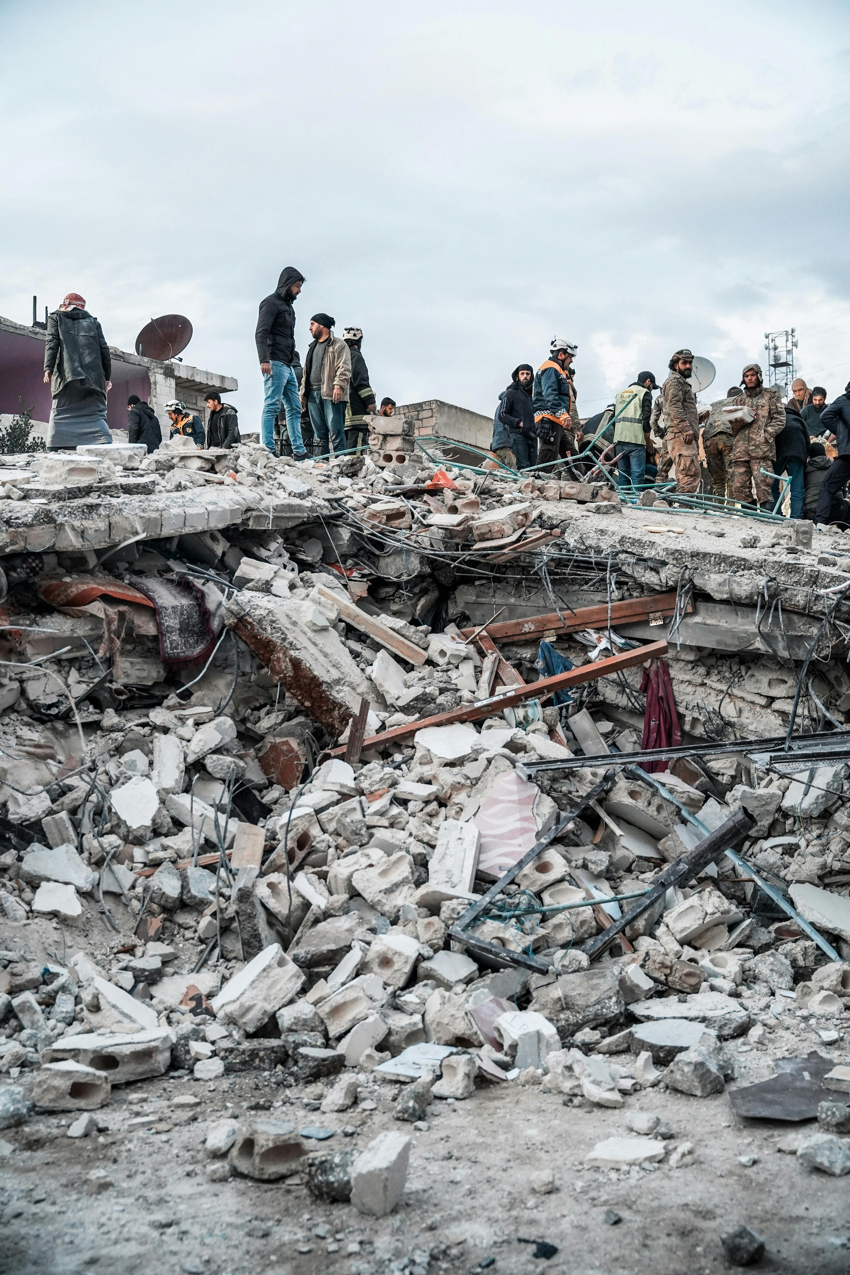 Emergency response team working at a disaster zone surrounded by debris, illustrating the importance of resilient, real-time communication powered by decentralized networks and AI-driven support during crises.