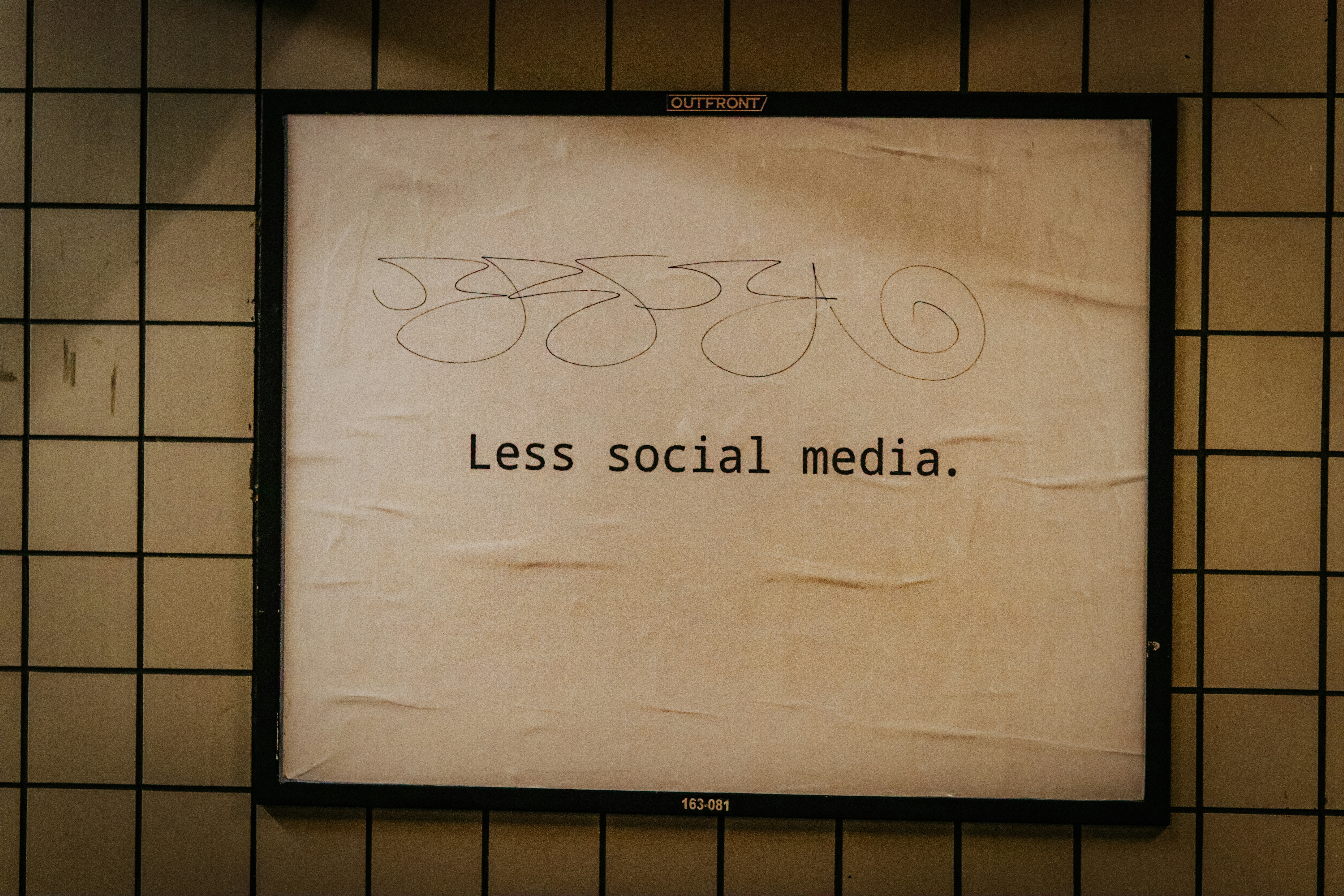 a sign on a wall that says less social media