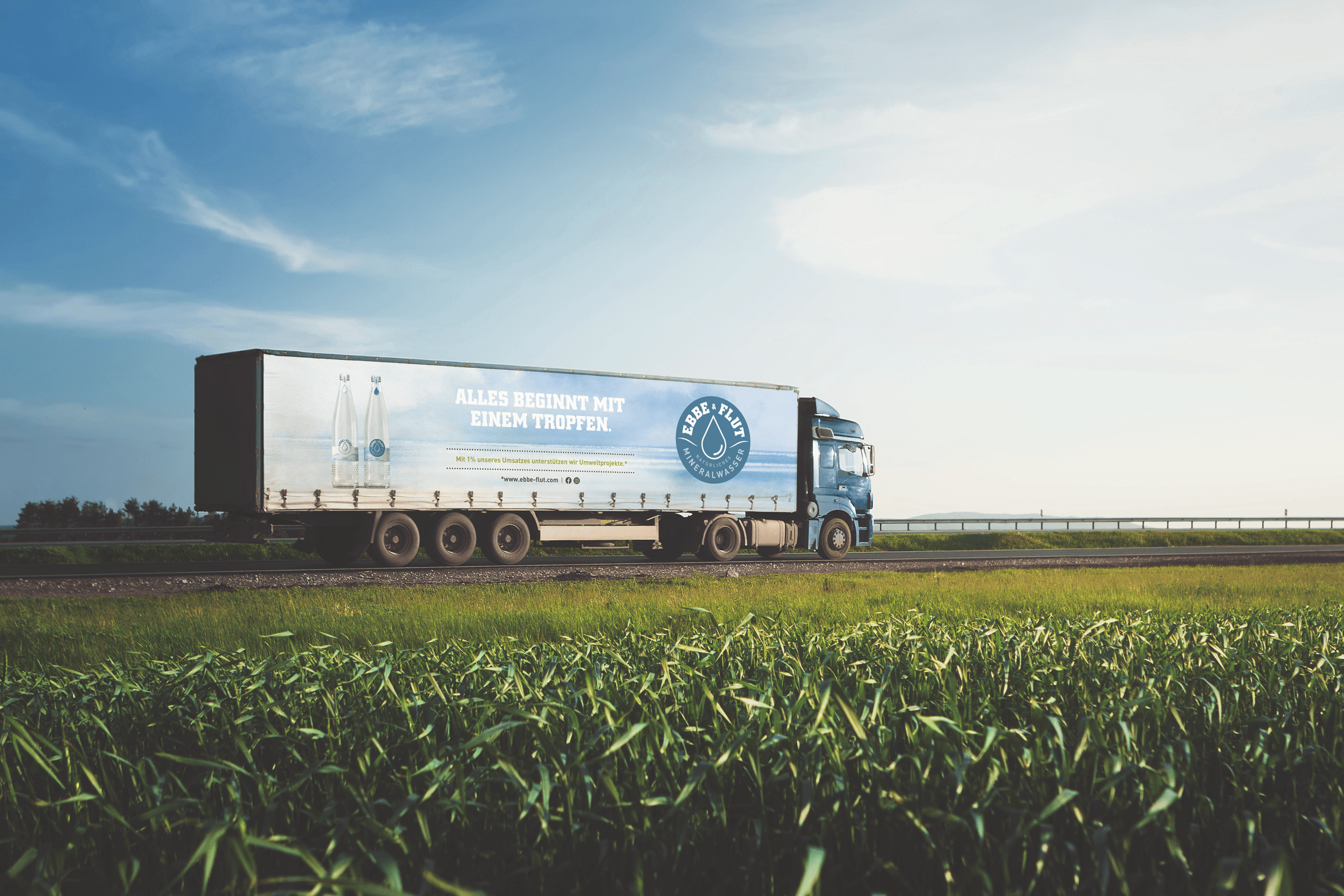 Truck with "Ebbe & Flut" branding driving on a road.