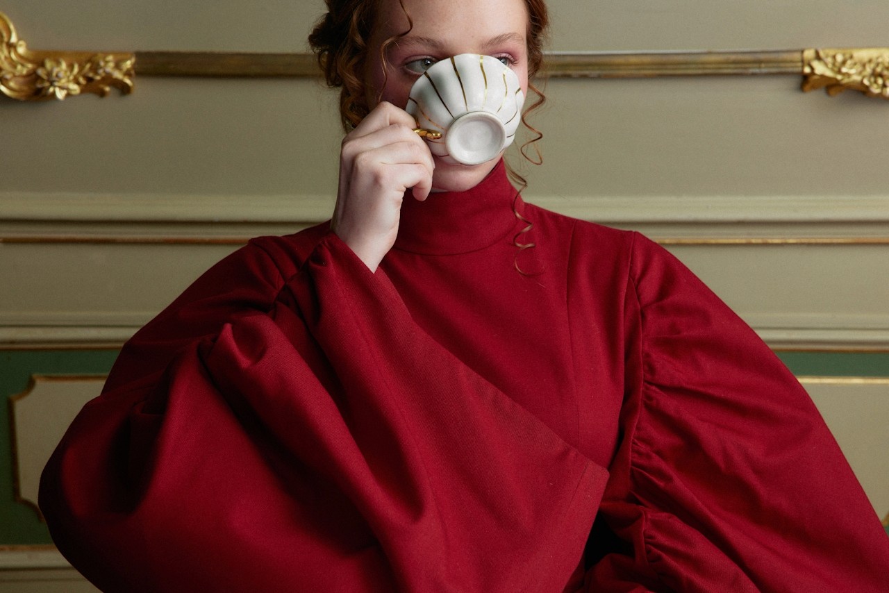 Woman drinking a cup of tea while seated and enjoying a quiet moment.