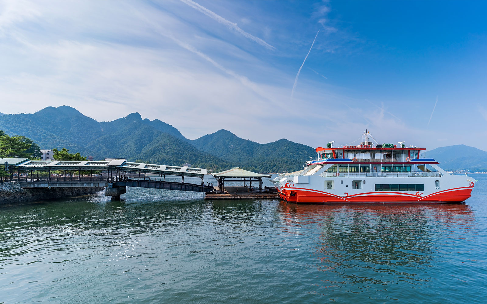 ہیروشیما کے دورے کا حصہ، پہاڑوں کے پس منظر میں میاجیما جزیرے پر فیری لنگر انداز ہو گئی۔