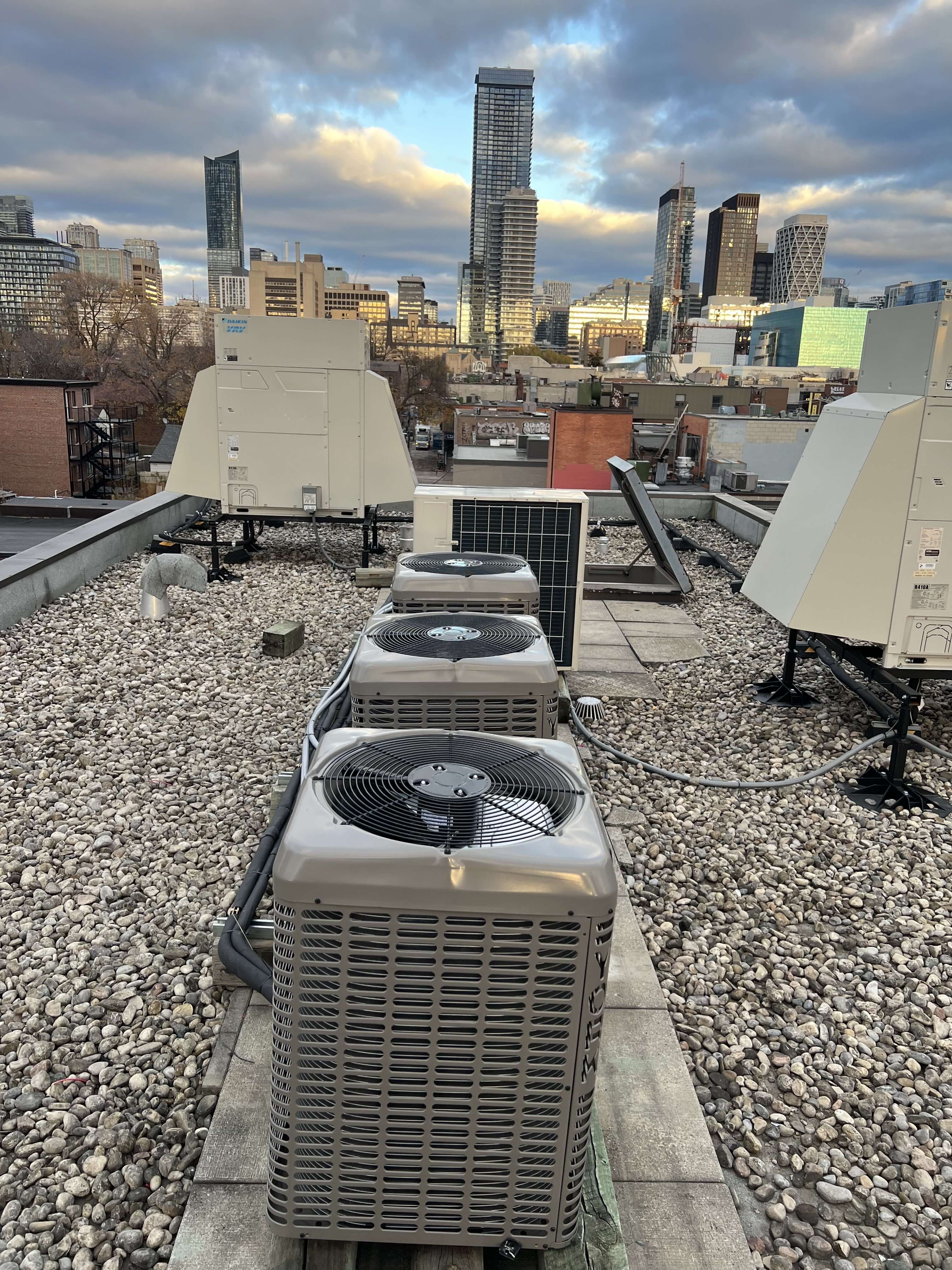 three air conditioners installed on top of a roof in downtown Mississauga