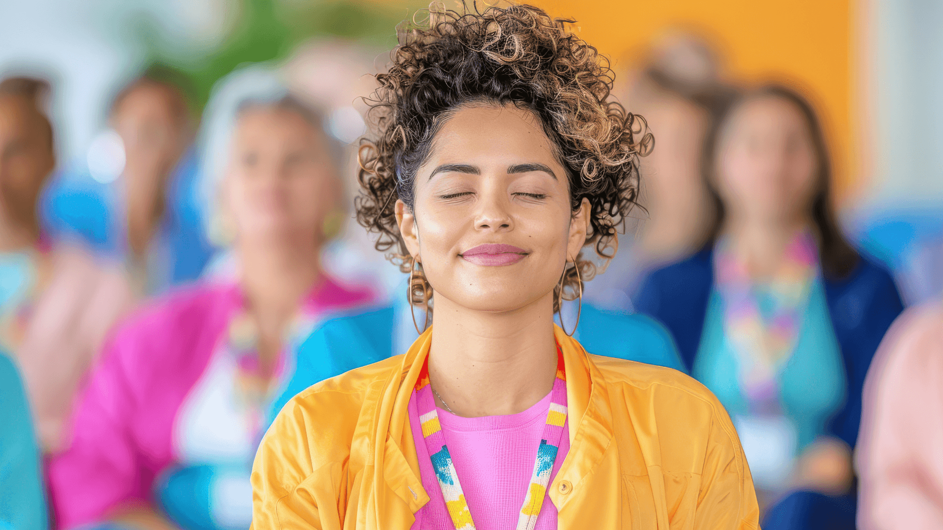 A winding road cuts through rocky terrain, surrounded by patches of green grass and illuminated by sunlight.