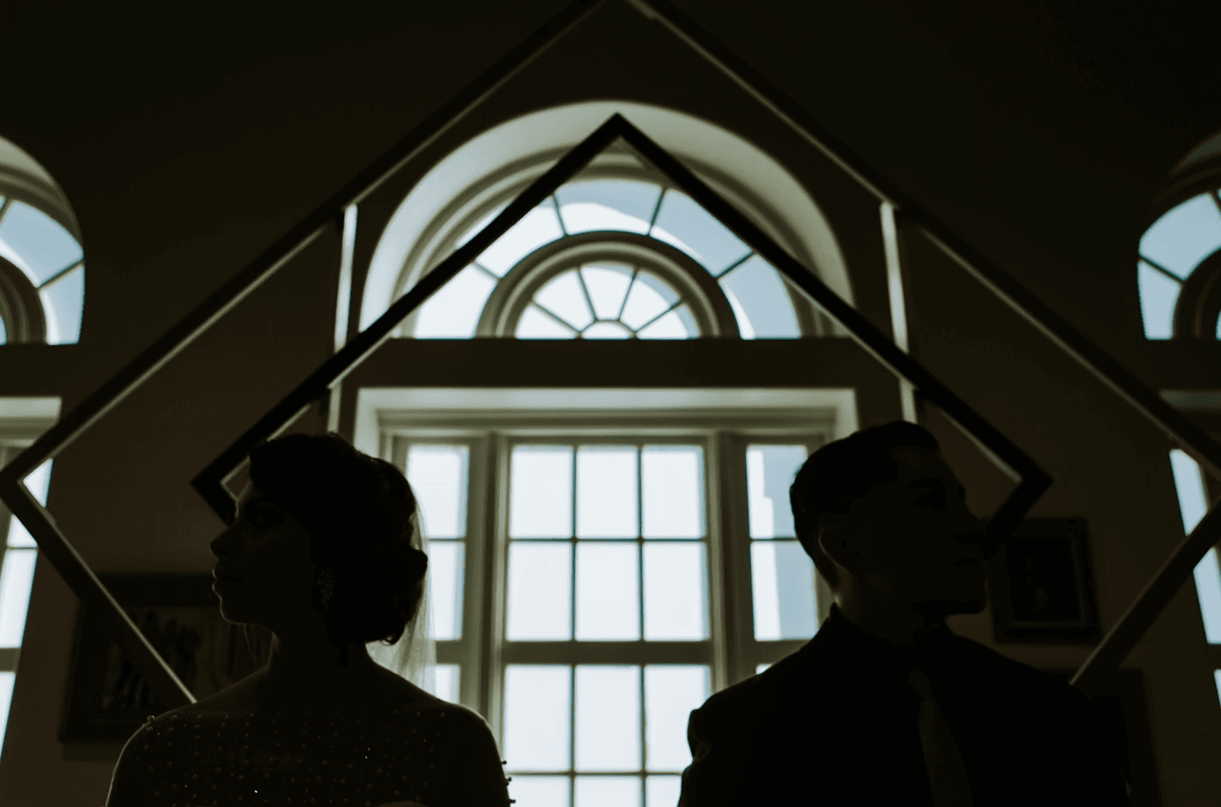 man and woman standing near window