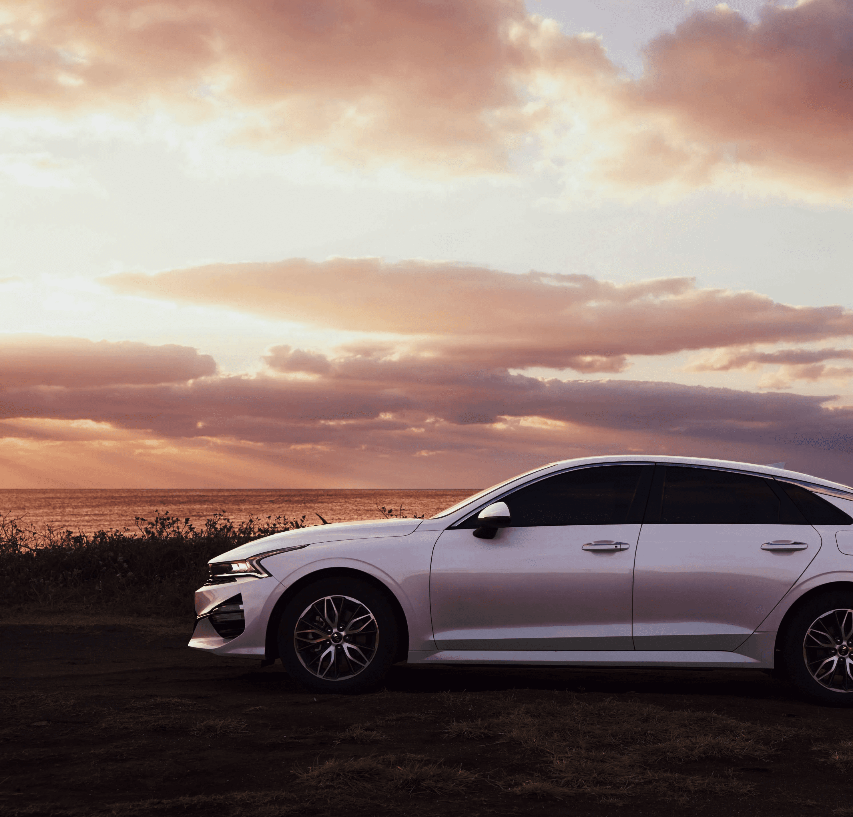 A serene and elegant spa space with wooden reclining chairs and white cushions. Golden sunlight filters through a cascading water feature, creating a peaceful atmosphere. Tropical plants and candles add to the relaxing ambiance.