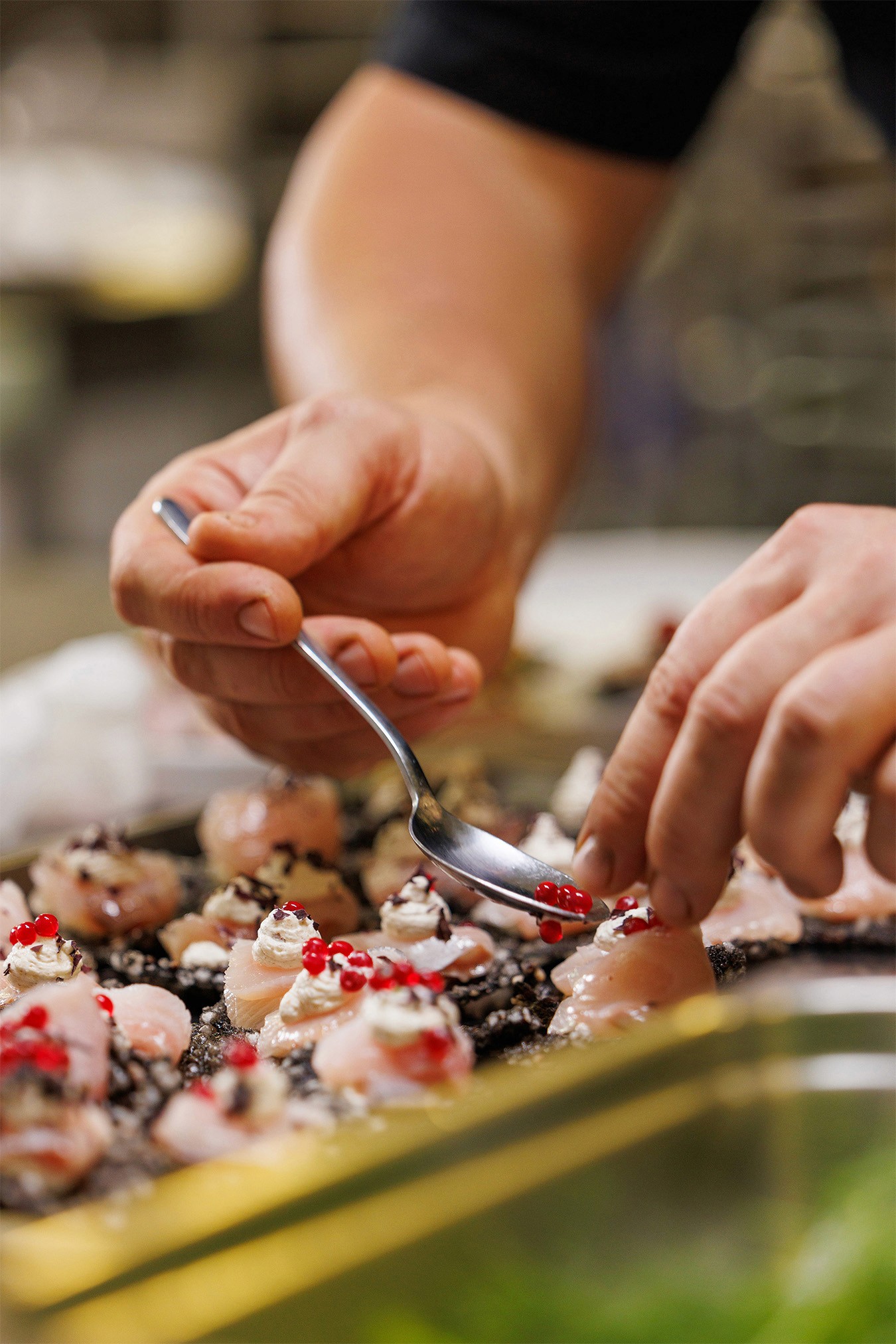 Chef plating Kingfish canape in the kitchen