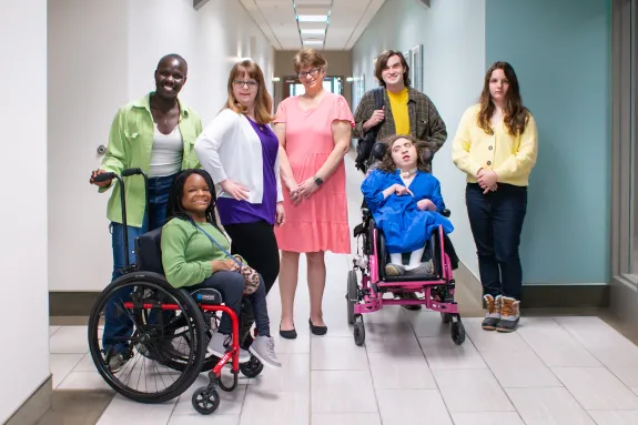 person in gray hoodie holding red and white box
