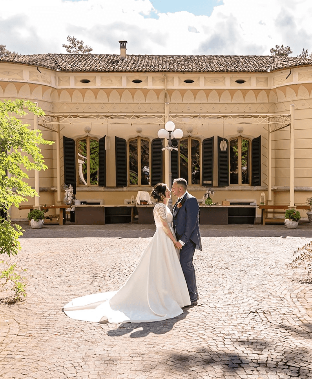 a large pink house with a pond in front of it