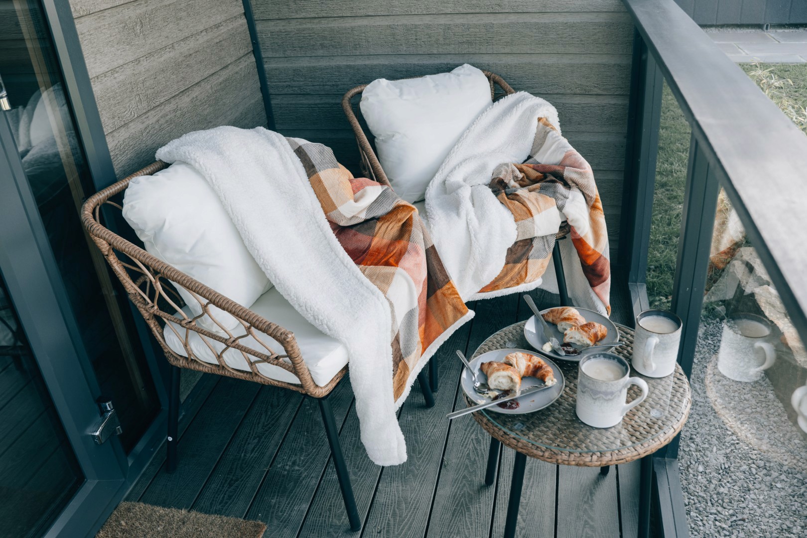 A couple of chairs with plates with crossaints on it. 
