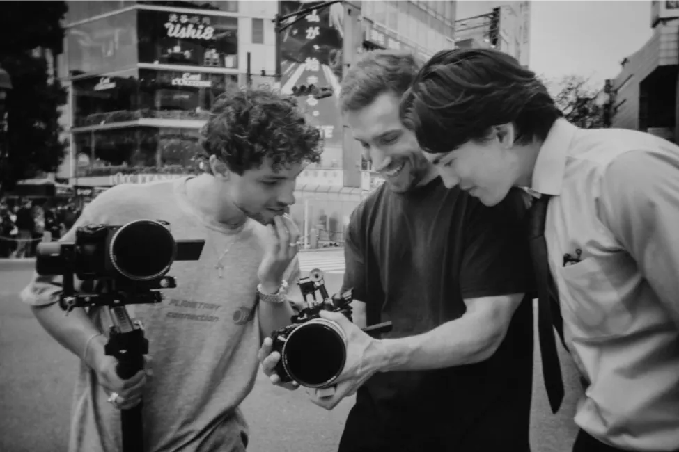 three people looking at a video on camera