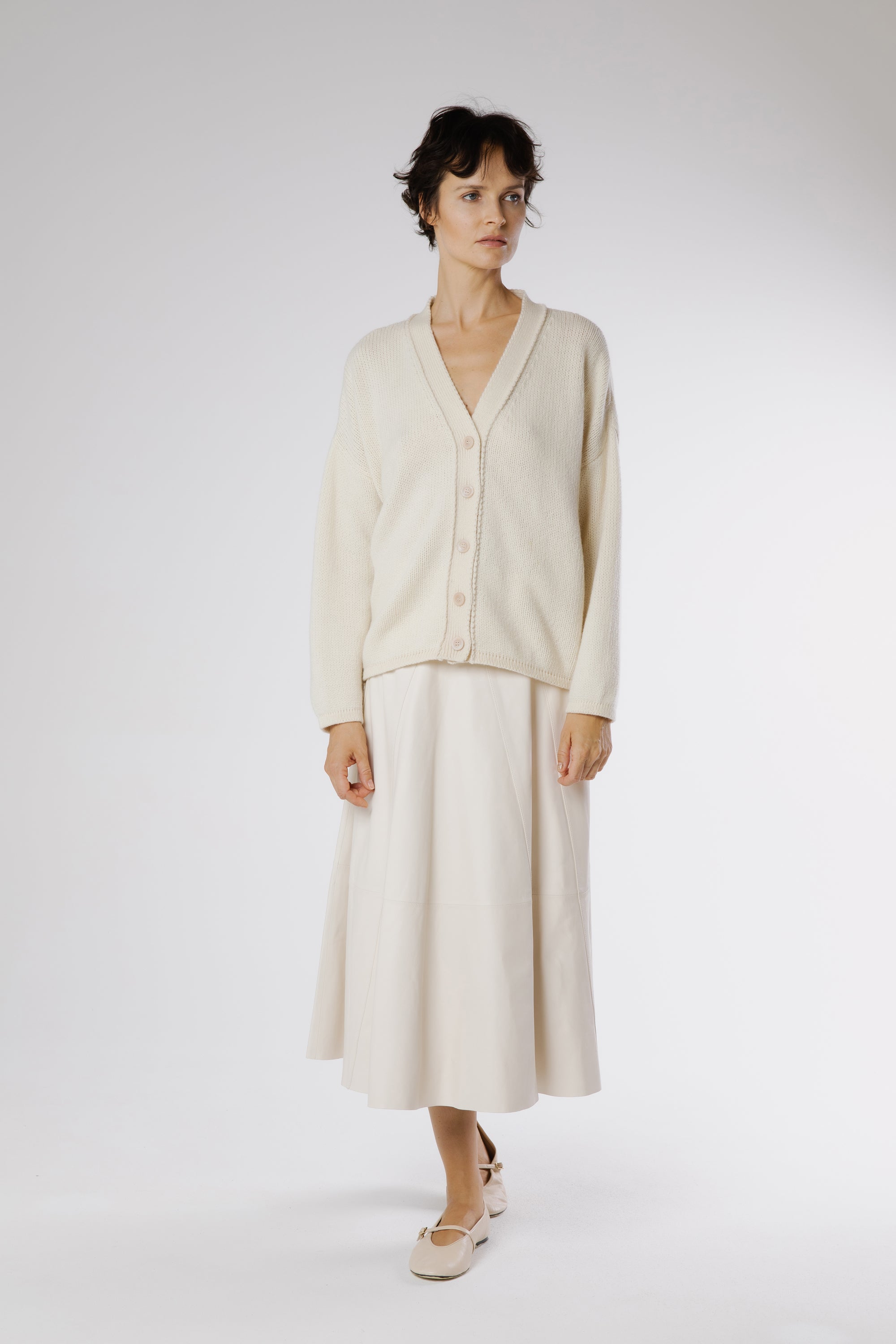 Full outfit featuring Milk leather midi skirt styled with soft knitwear and minimalist flats for refined everyday elegance.