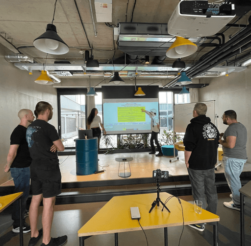 Rhino.fi team members gathered in a meeting room during a team presentation with a projector screen