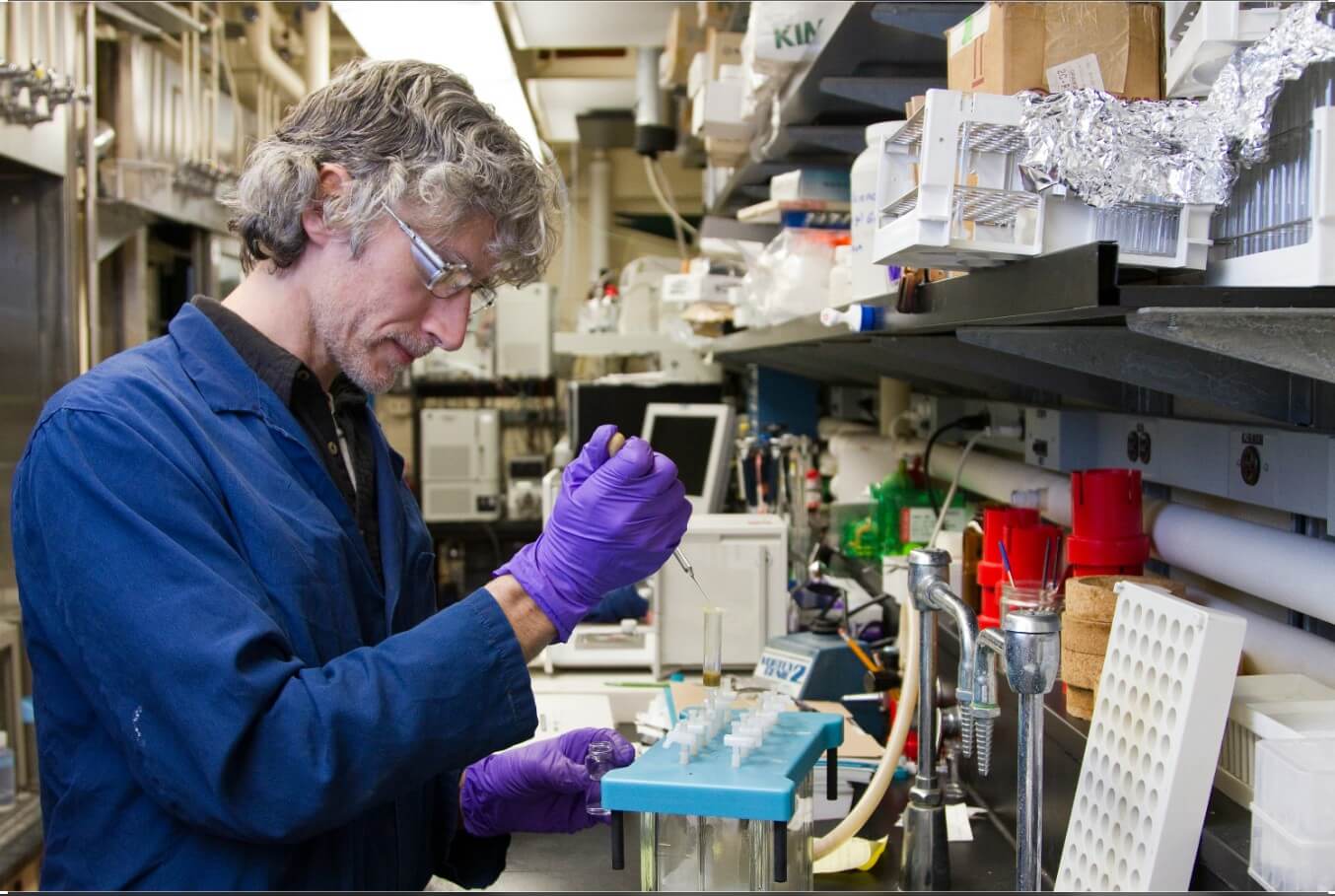 woman dropping a specimen on a test tube