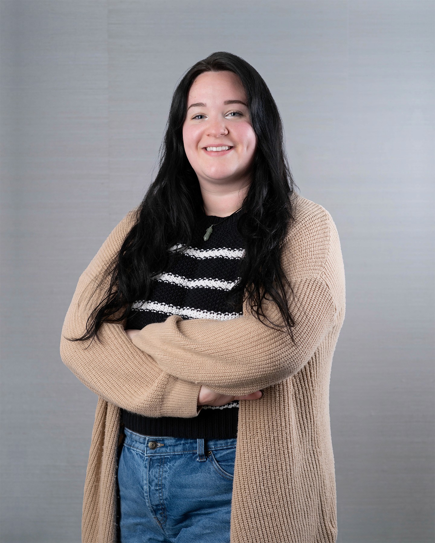 Young woman with long black hair, smiling gently.