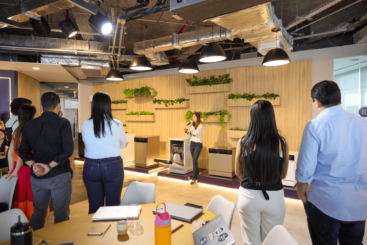 Smart speaker with glowing top next to a phone, set against a green background