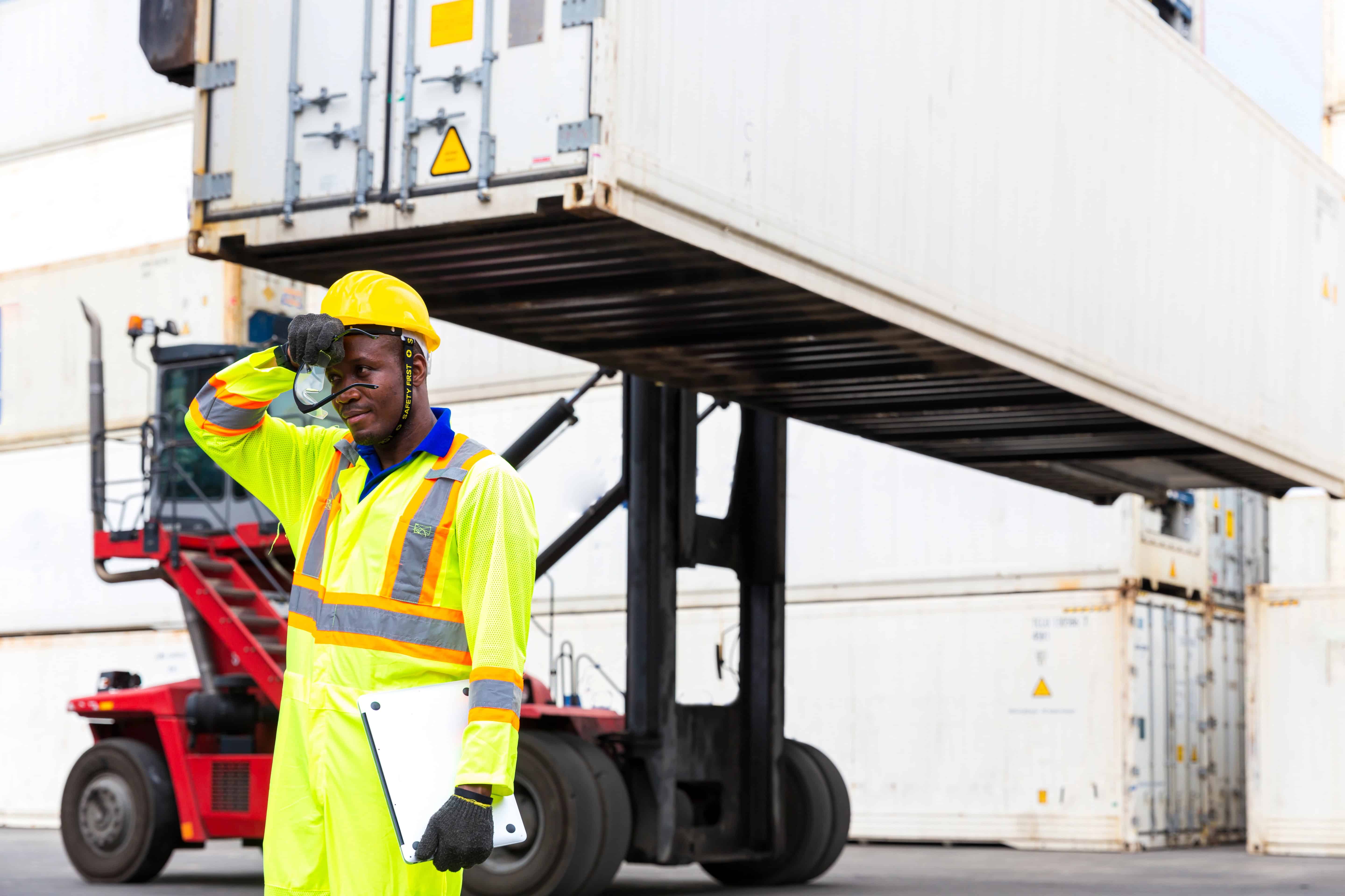 Worker in port unloading cargo dealing with fatigue and heat stress