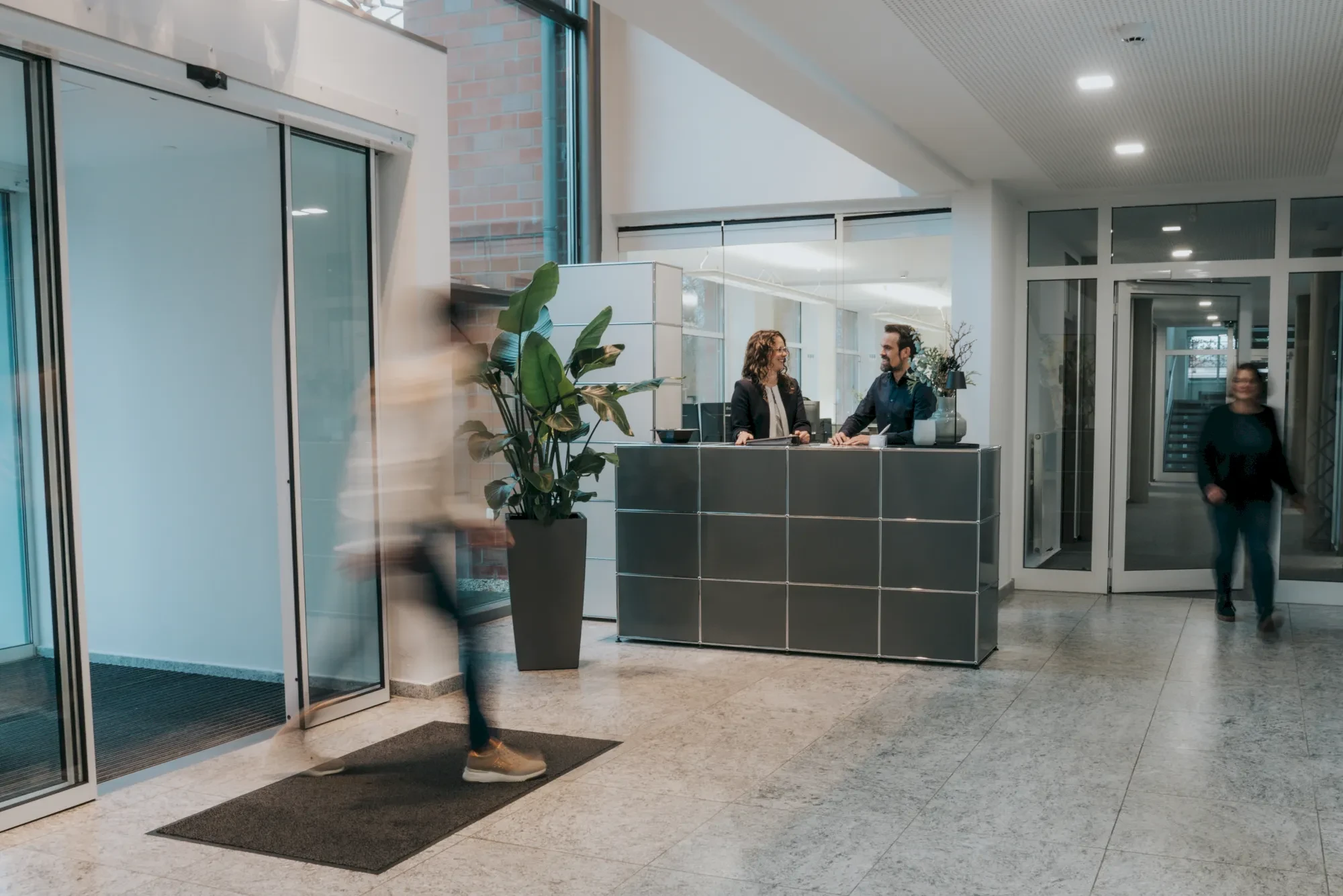 Empfangsbereich mit Rezeptionisten, Eingangshalle, Büroumgebung, Menschen